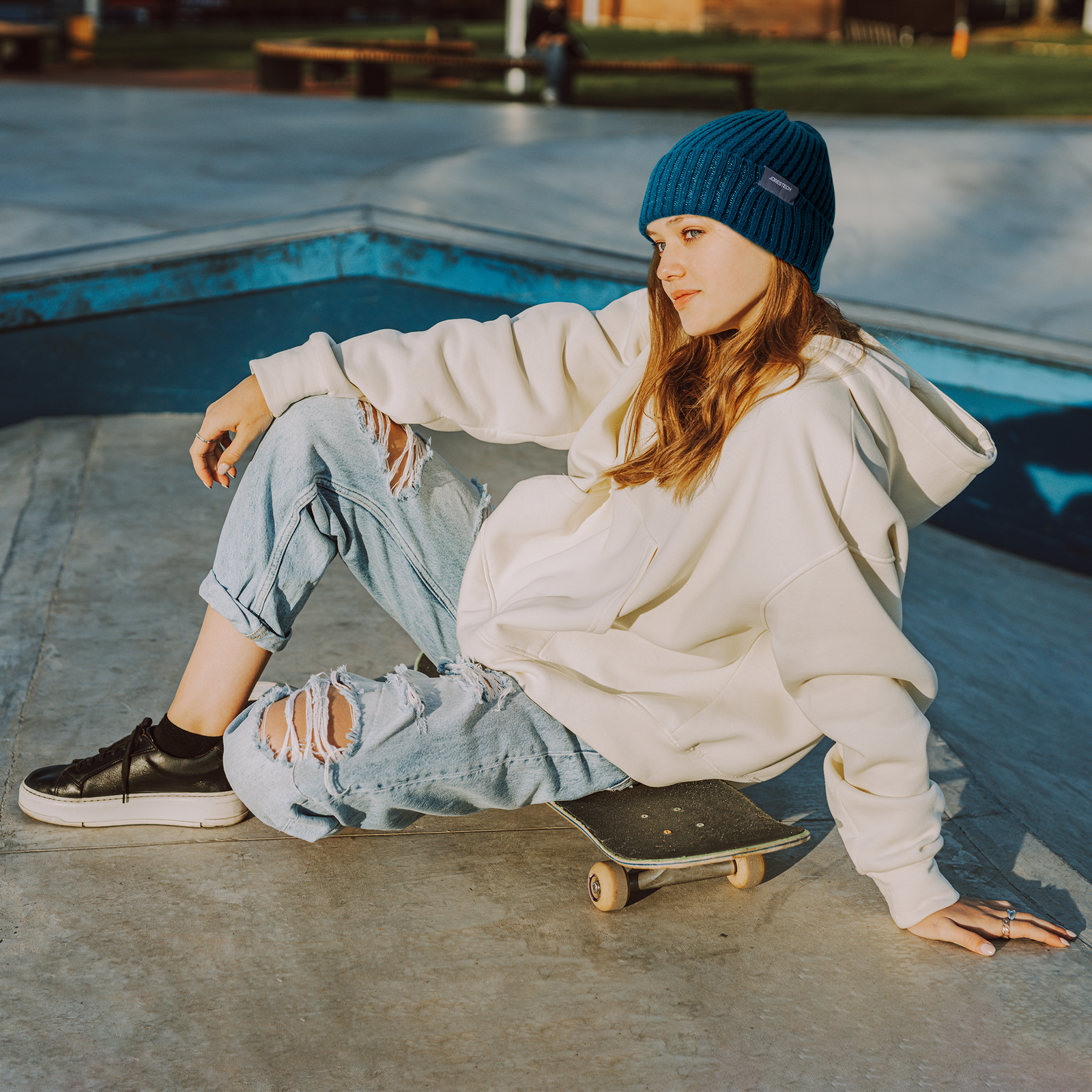 Woman wearing a blue beanie hat with reflective stitching for roller bladding