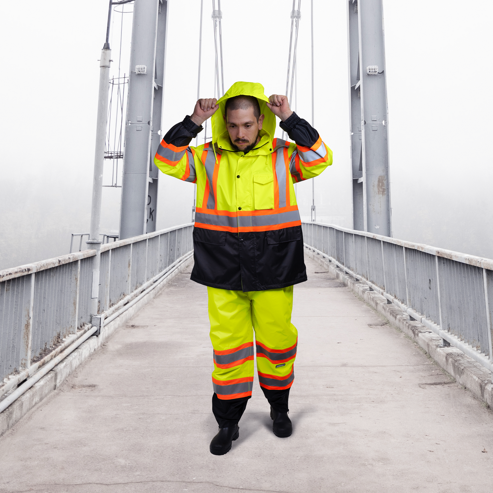 Worker wearing the two tone yellow safety rain set in a cloudy day on a bridge.
