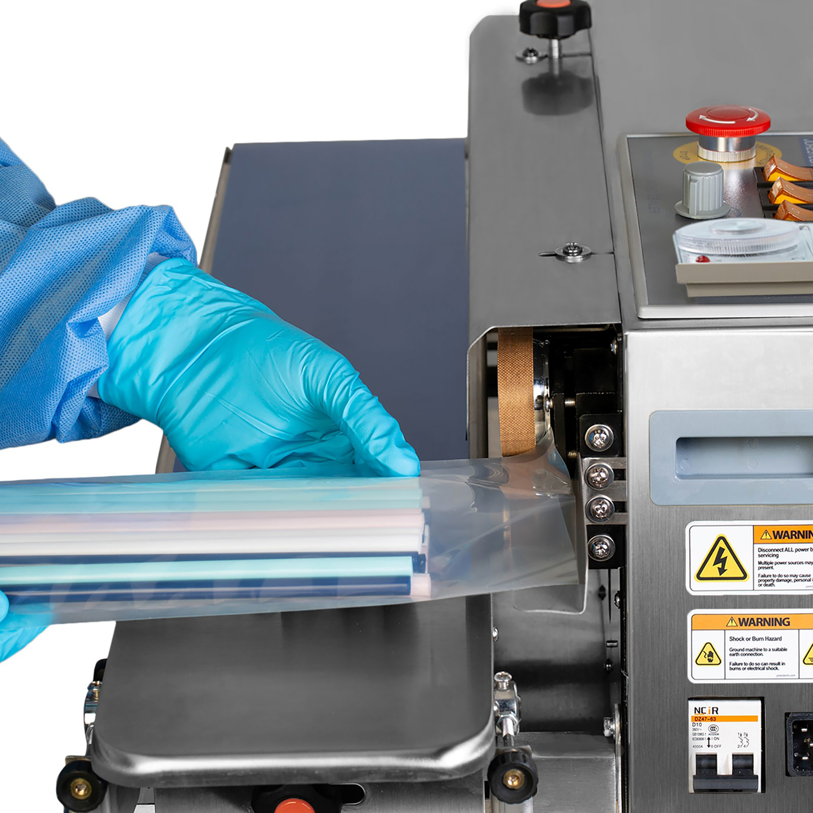 A person wearing disposable gloves and clothe using the JORES TECHNOLOGIES® band sealer to seal a clear plastic bag filled with straws. The machine is set in an Horizontal position while the bag moves laying on the revolving band.