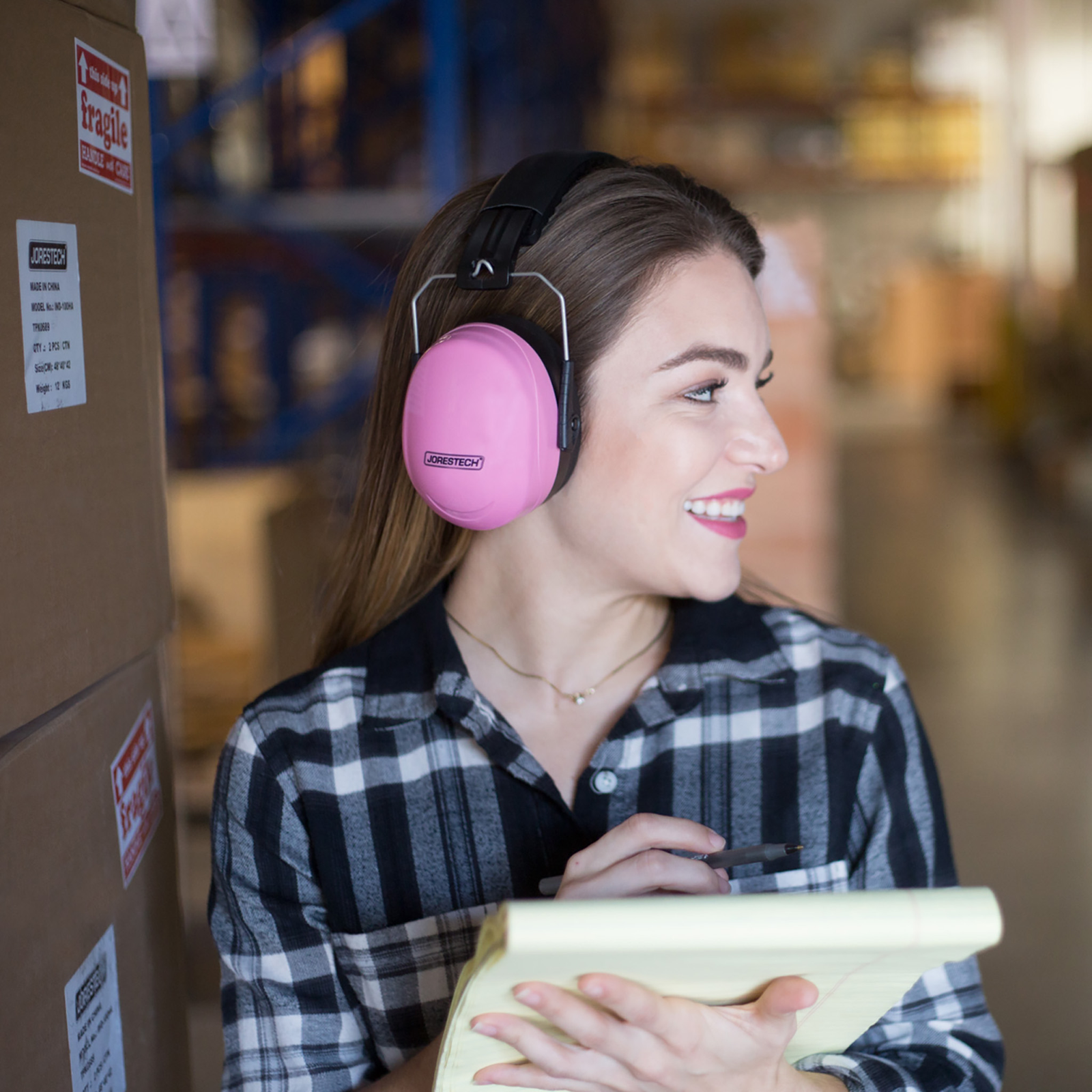 Women wearing the JORESTECH pink earmuffs while working keeping inventory of many boxes