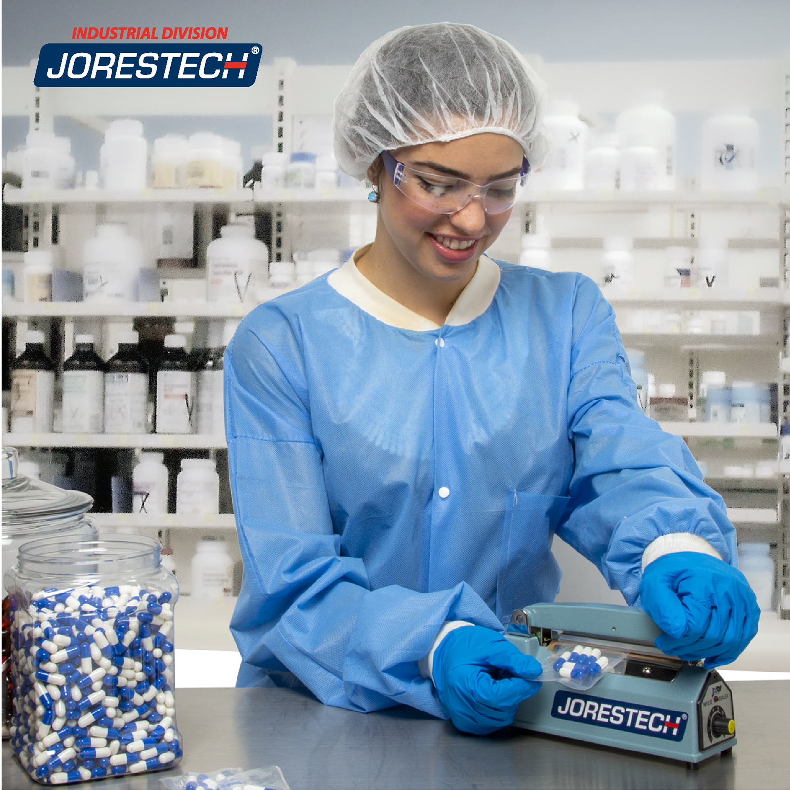 Woman in a lab setting featuring an array of medicine jars on shelves. She is wearing a disposable hair net, robe, glasses, and gloves and she is operating the JORES TECHNOLOGIES® 4 inch manual impulse sealer to seal a bag with several blue and white pills