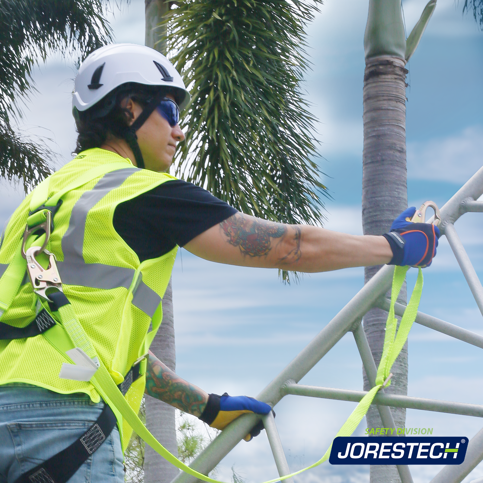Worker climbing a metal structure while wearing harness with a JORESTECH adjustable work positioning lanyard with self looking snap hooks