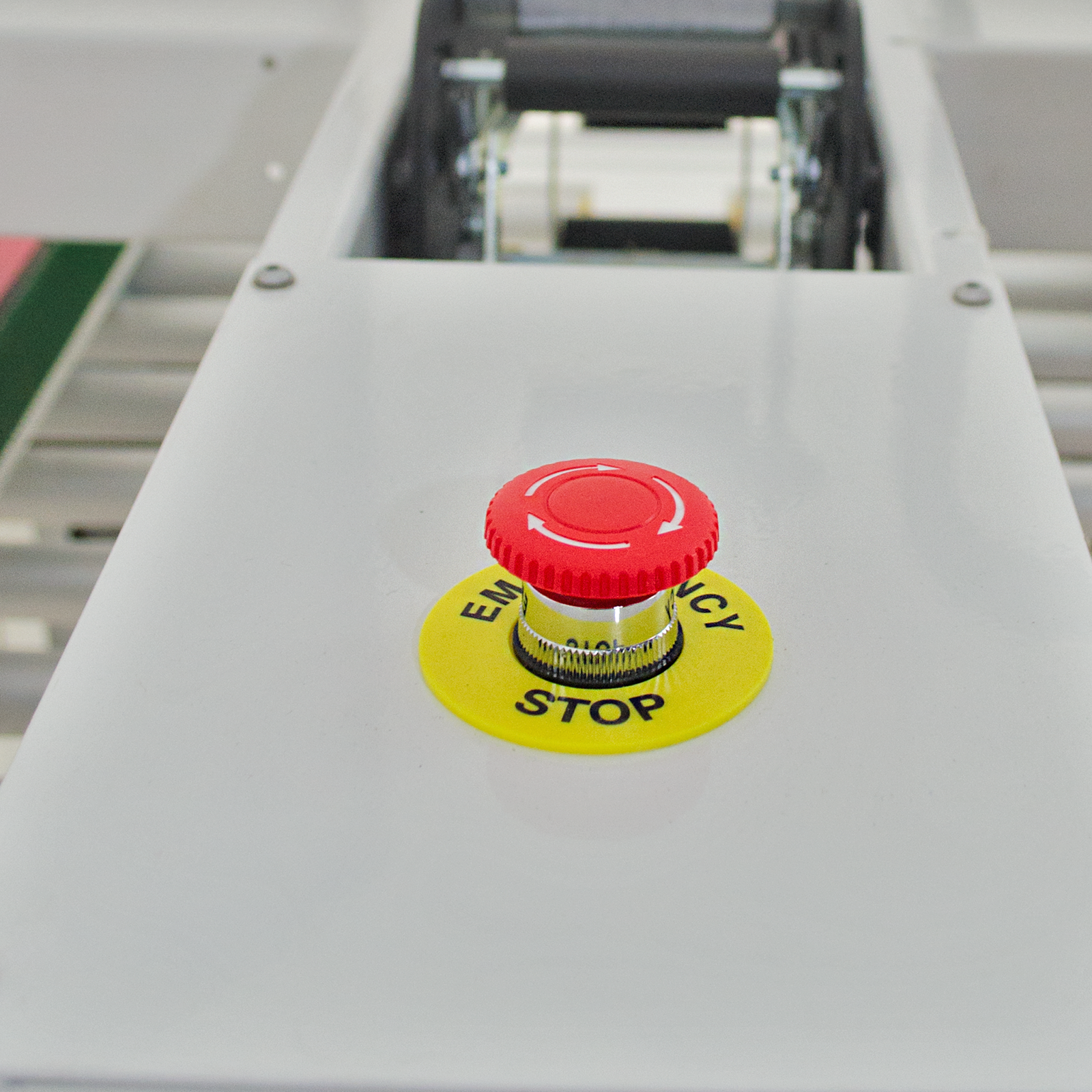 red emergency stop button with yellow label on white case sealer machine