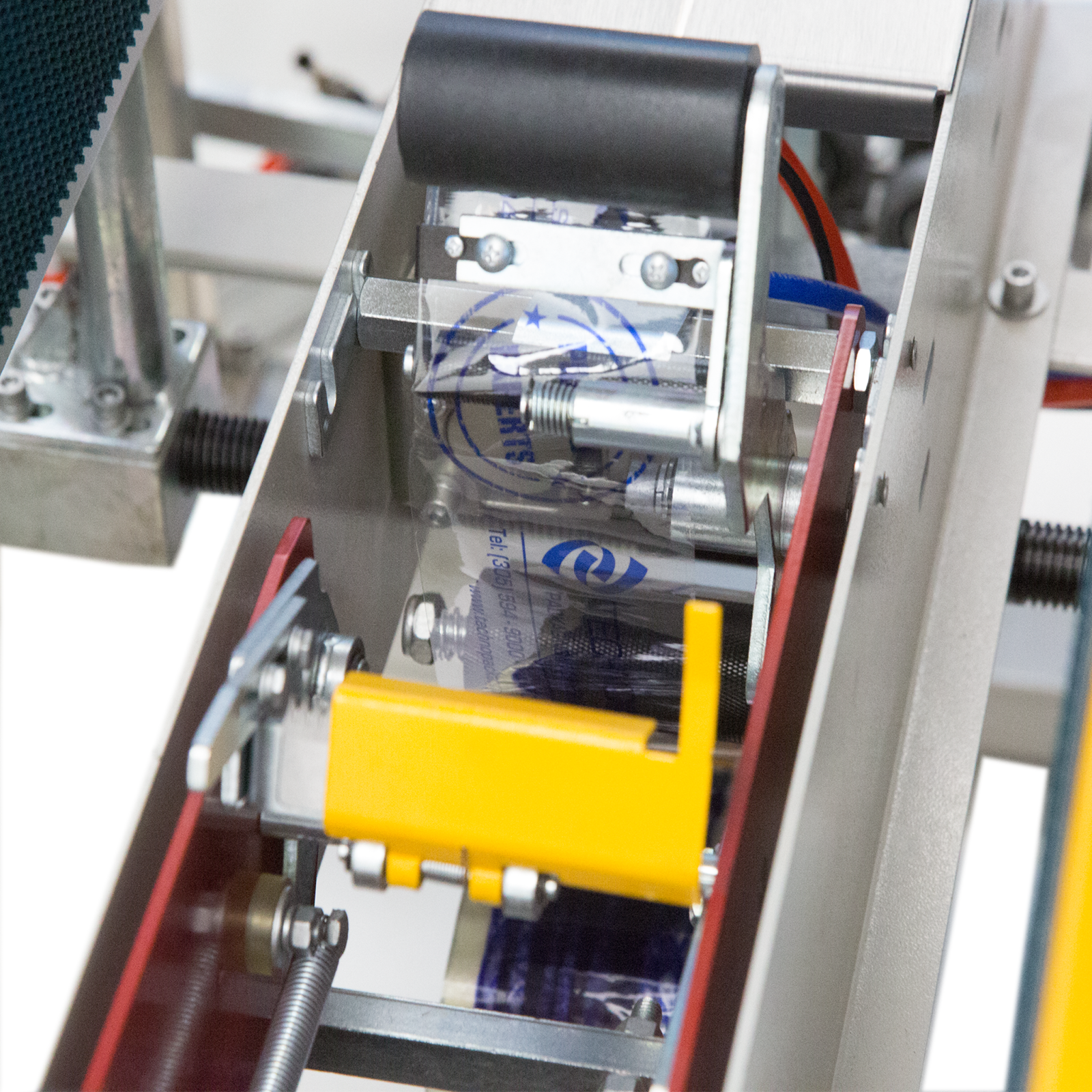 clear sealing tape revolving around dispensing rollers of the automatic case erector with bottom tape sealer