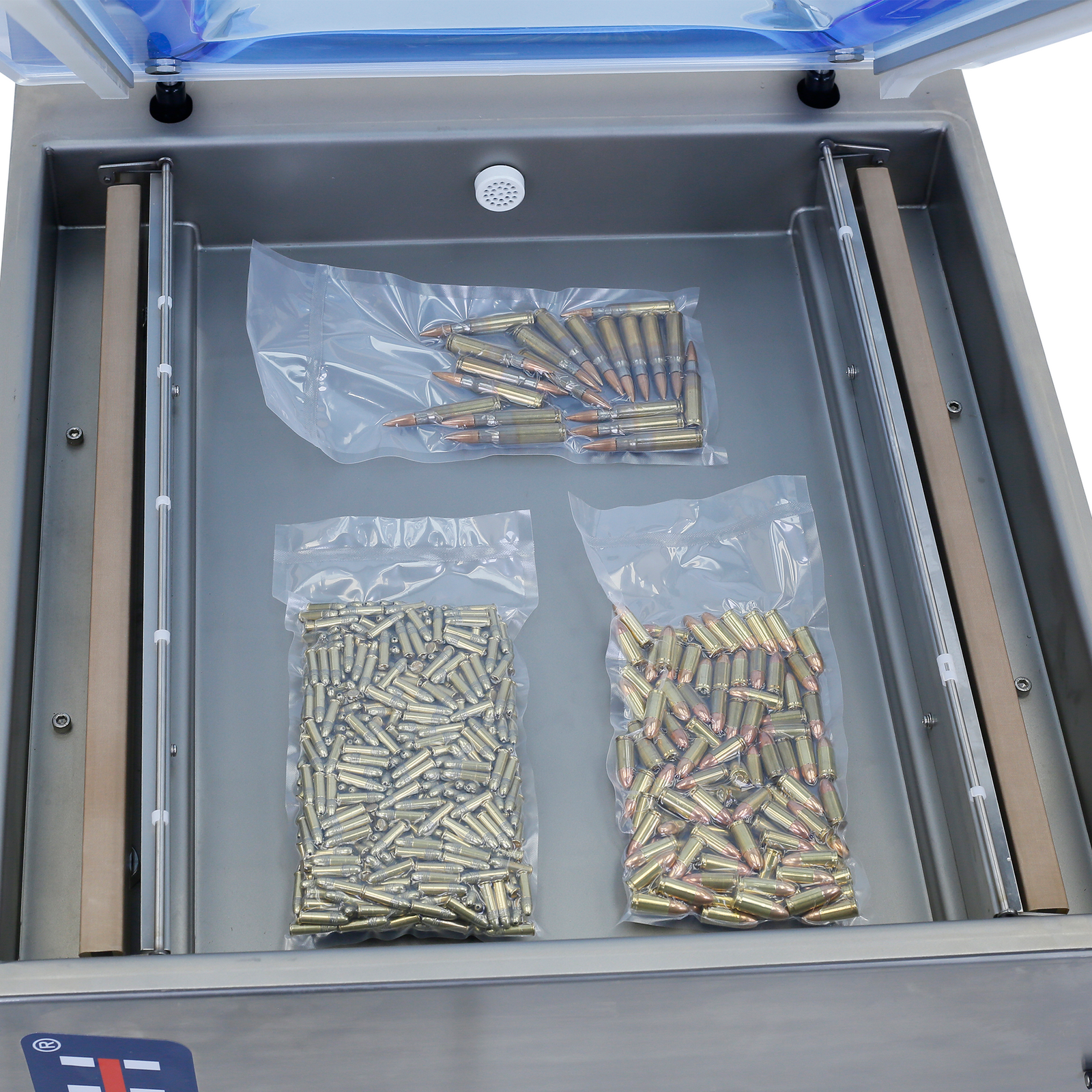 The interior of the chamber of the Jorestech vacuum sealer and the 2 sealing bars. Inside the chamber are 3 bags with metal items completely vacuumed to avoid weather exposure and oxidation. Metals are usually vacuumed to protect them from getting rusted
