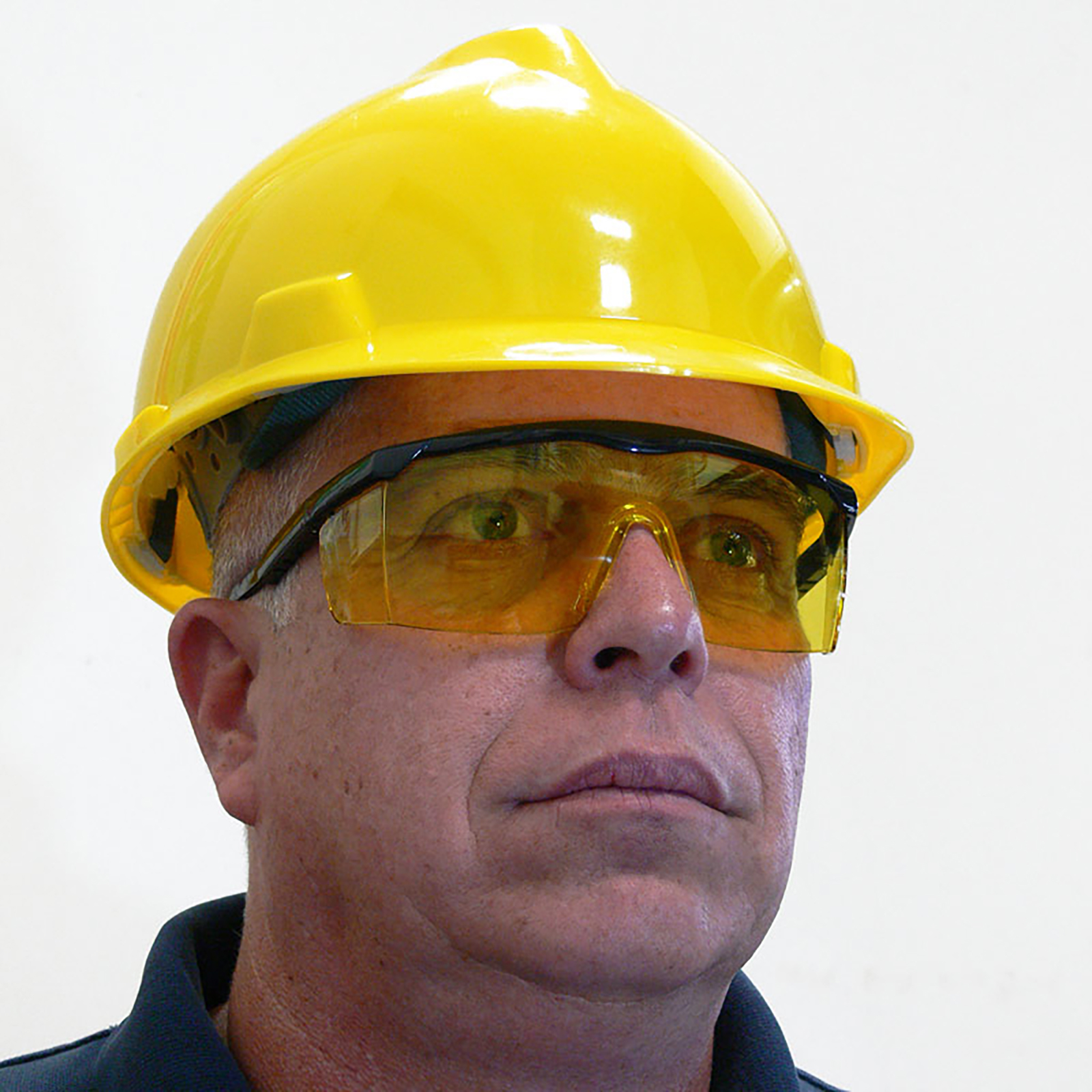 Man wearing a yellow cap stile hard hat and the JORESTECH framed rectangular safety glasses with UV protection and side shields for high impact protection