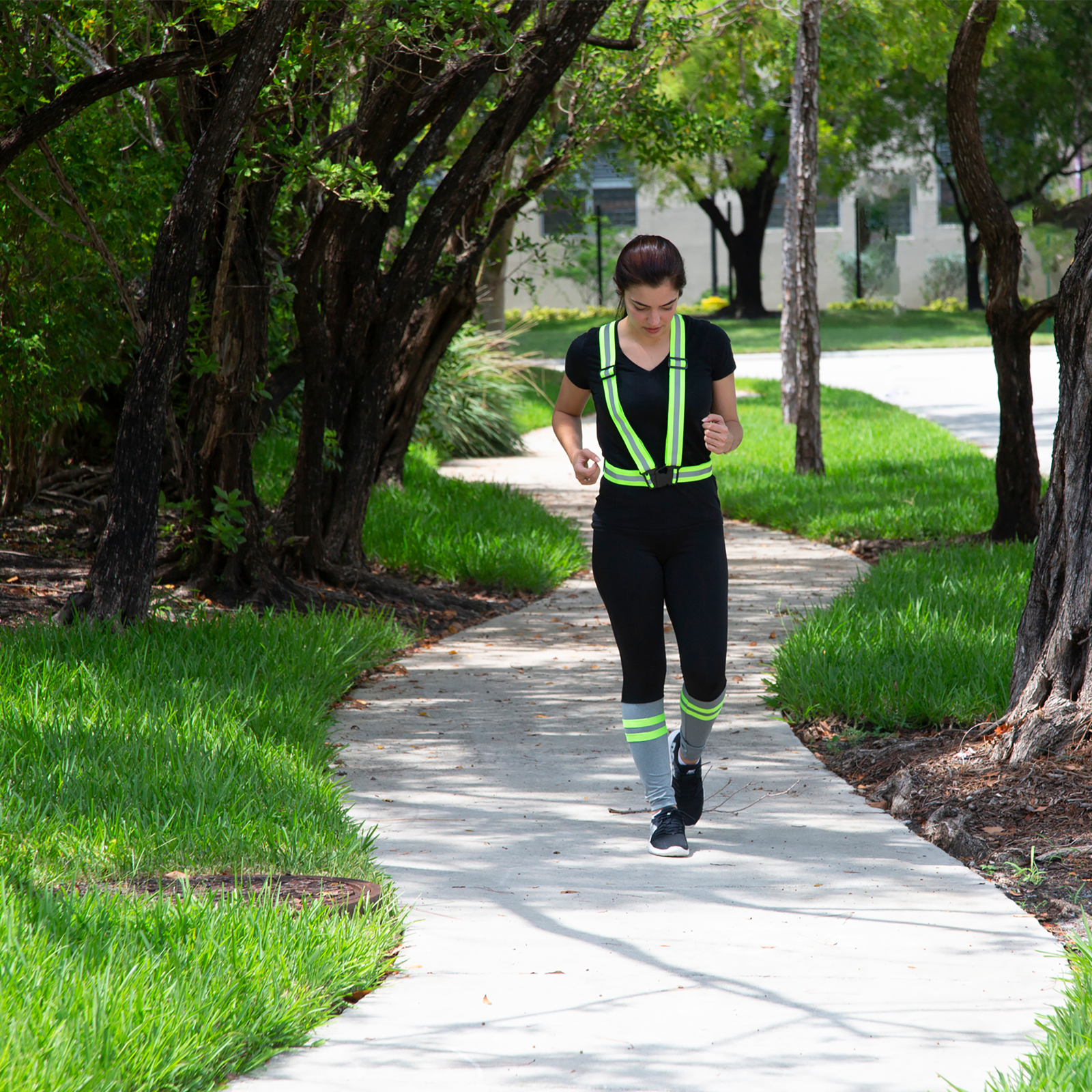 A person wearing a JORESTECH safety suspender for jogging next to the road