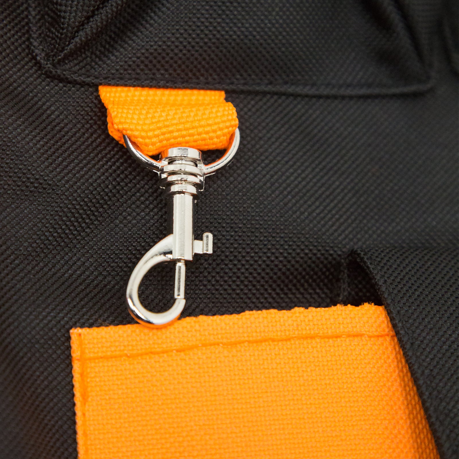 Close up shows a small metal carabiner as part of the tool vest