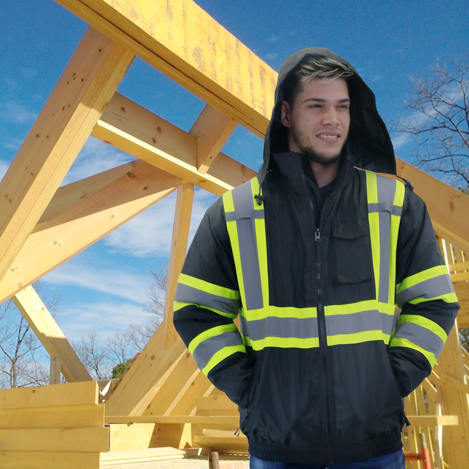 Worker on top of a wood roof construction wearing the black and yellow hi-visibility two tone safety bomber jacket with reflective stripes and X on the back for winter protection
