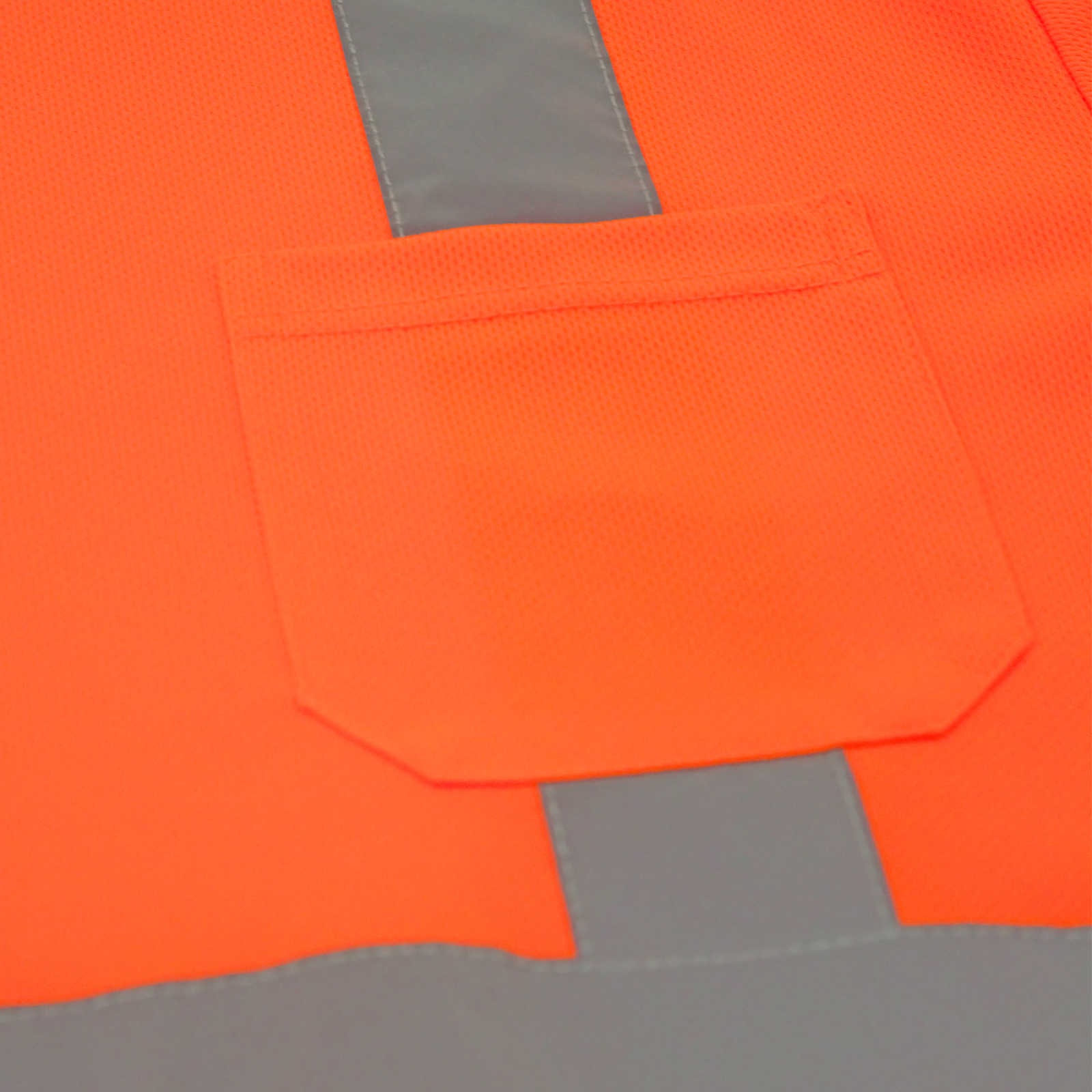 Close up of the chest pocket, the reflective strips and the polyester breathable birds eye fabric of a Hi-Vis ANSI safety shirt