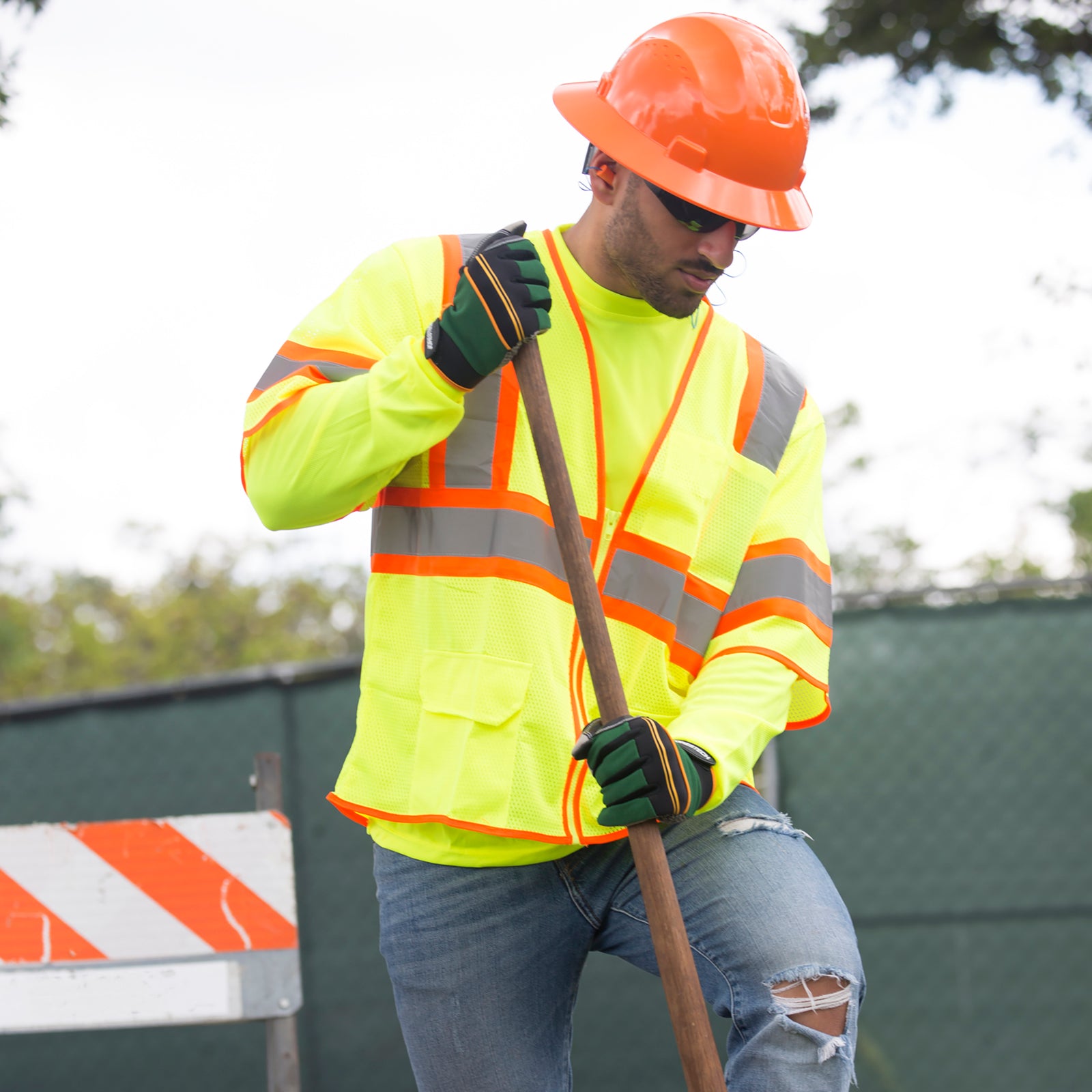 Worker wearing a lime safety vest for road protection while working in a construction.