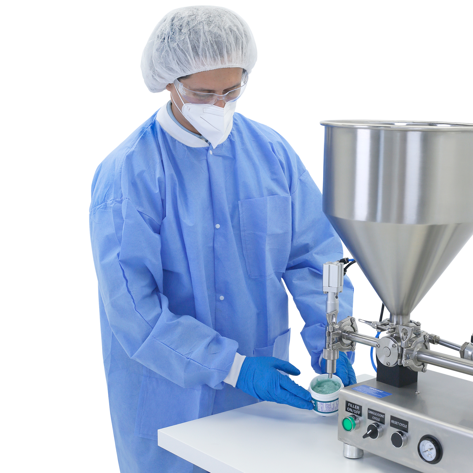 An operator wearing PPE clothing and disposable gloves standing in front of the nozzle of a Piston filler. He is removing a container filled with a blue viscos gel after been filled by the stainless steel JORES TECHNOLOGIES® piston filler with hopper that is placed on top of a working table