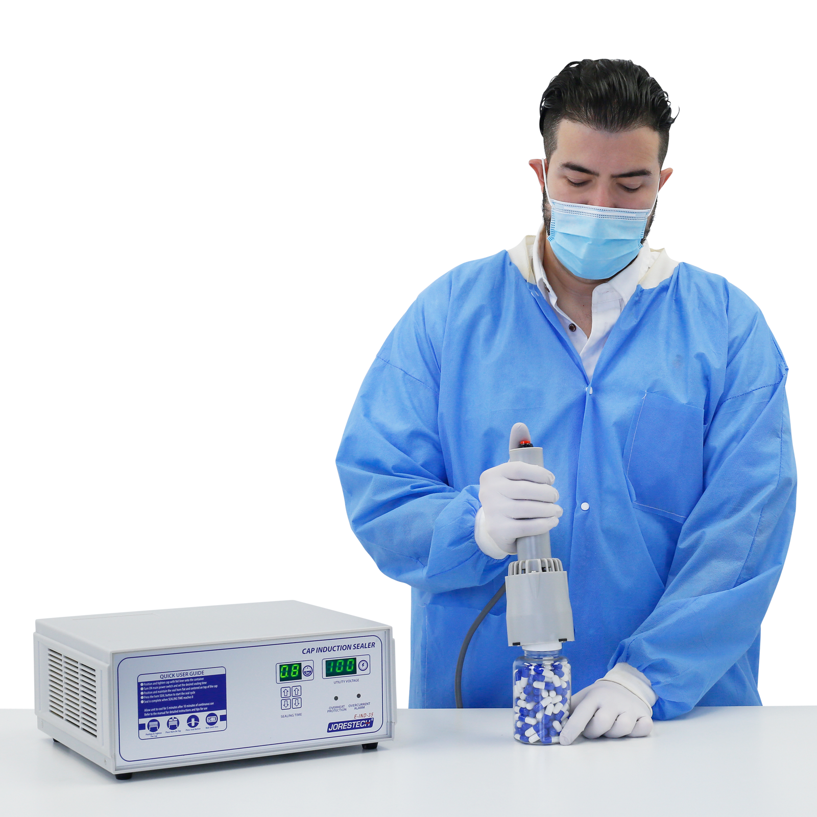 Person in a lab wearing personal protection equipment. He is sealing a bottle filled with pills with induction liners for tamper protection using the Jorestech induction cap sealer