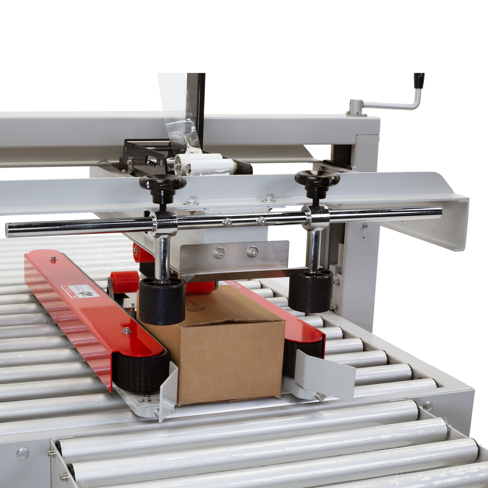 Detail shot of a box being pushed forward by the side traction belts on a JORES TECHNOLOGIES® CCN-110 Case and box closing taping machine.