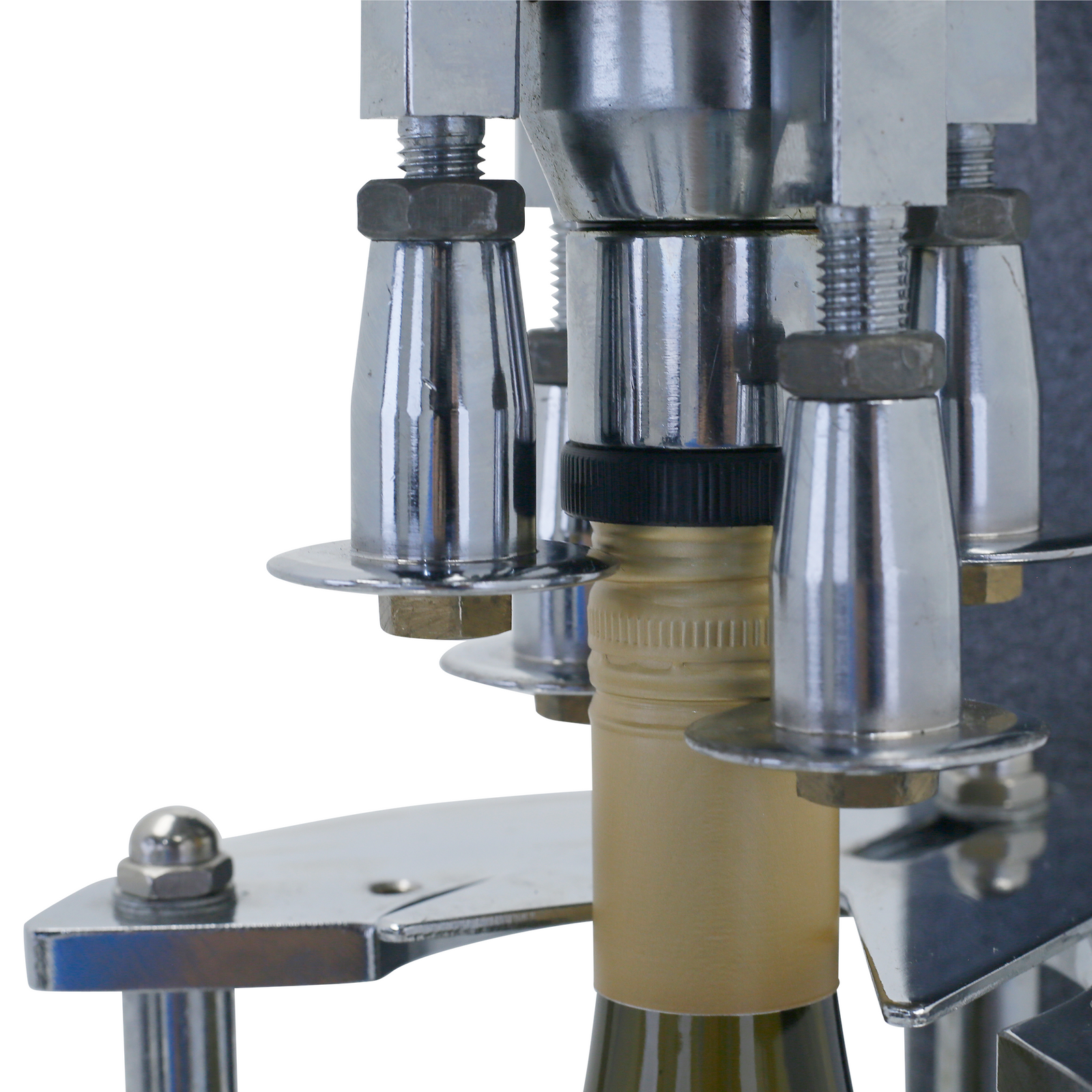 close of capping components on grey bottle capper with a gold cap inserted. Te capper is placing the cap on the top of the bottle.