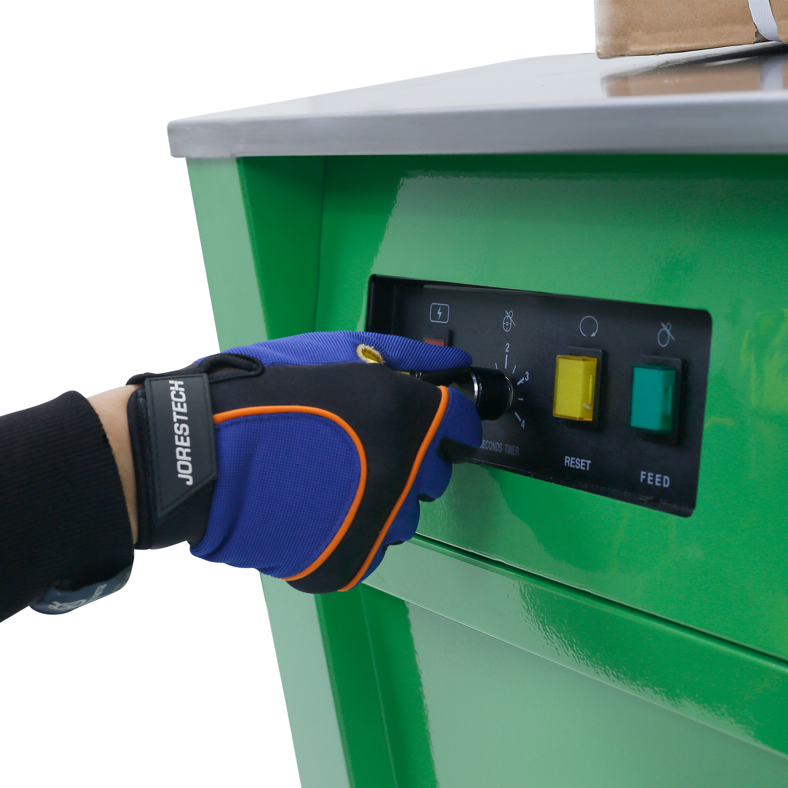 Close up of a person wearing protective gloves operating the JORES TECHNOLOGIES® semi automatic poly strapping machine