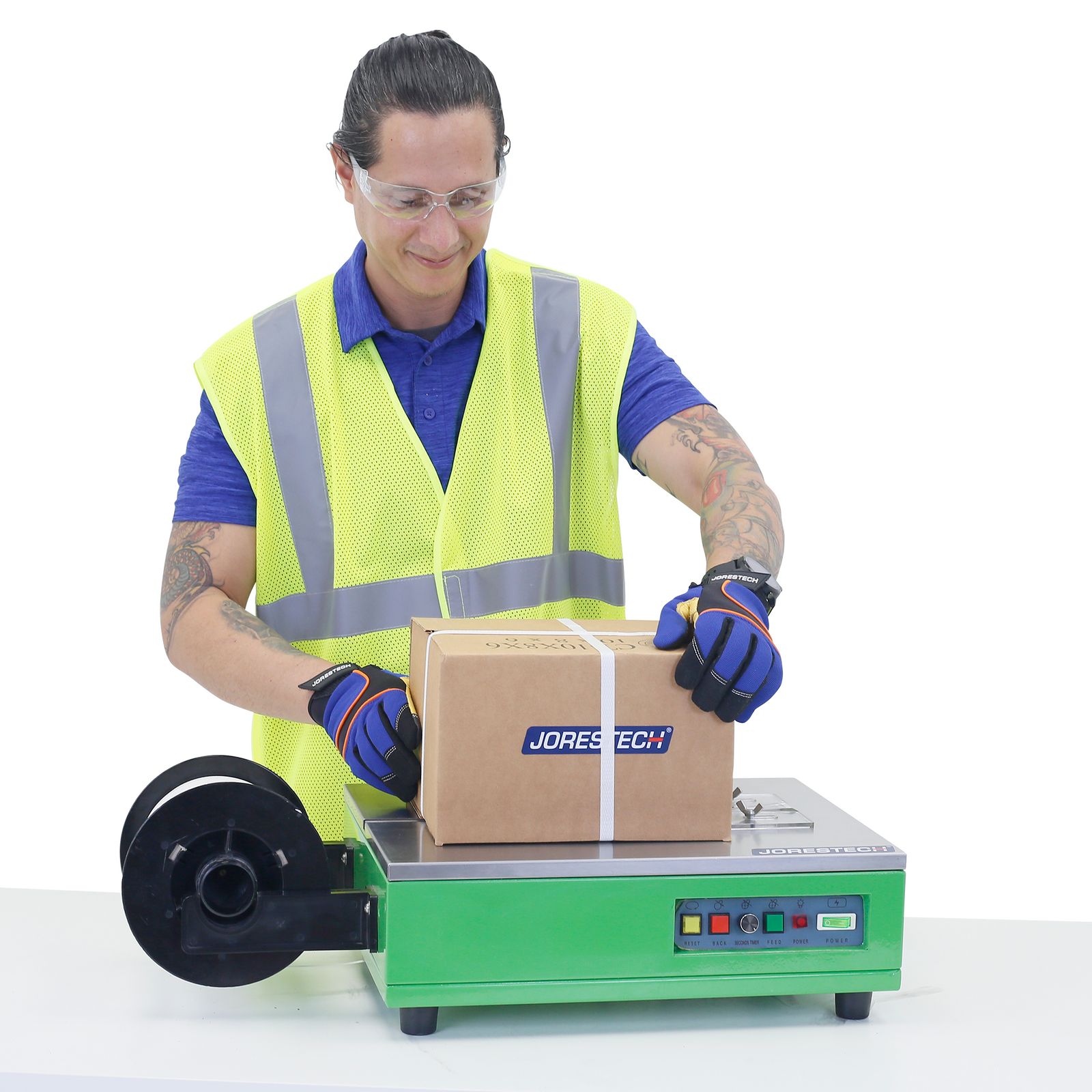 Worker  using the JORES TECHNOLOGIES® tabletop strapping and banding machine to secure a cardboard box for shipping