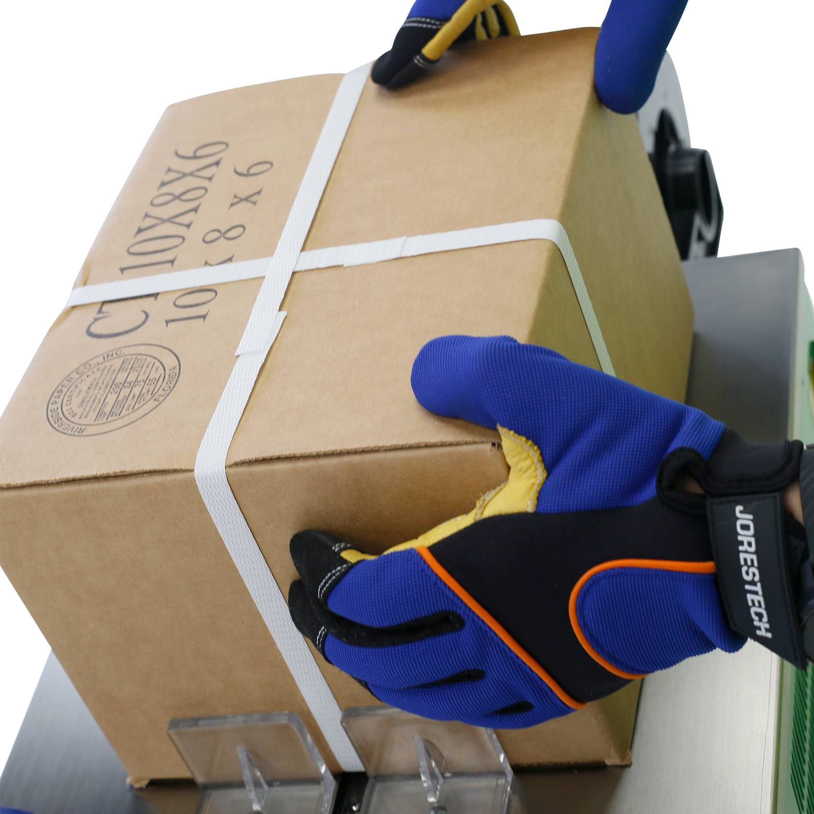 close-up of a cardboard box that has been protected by polypropylene white straps for shipping. The machine has been packaged using a JORES TECHNOLOGIES® low profile semi automatic strapping machine