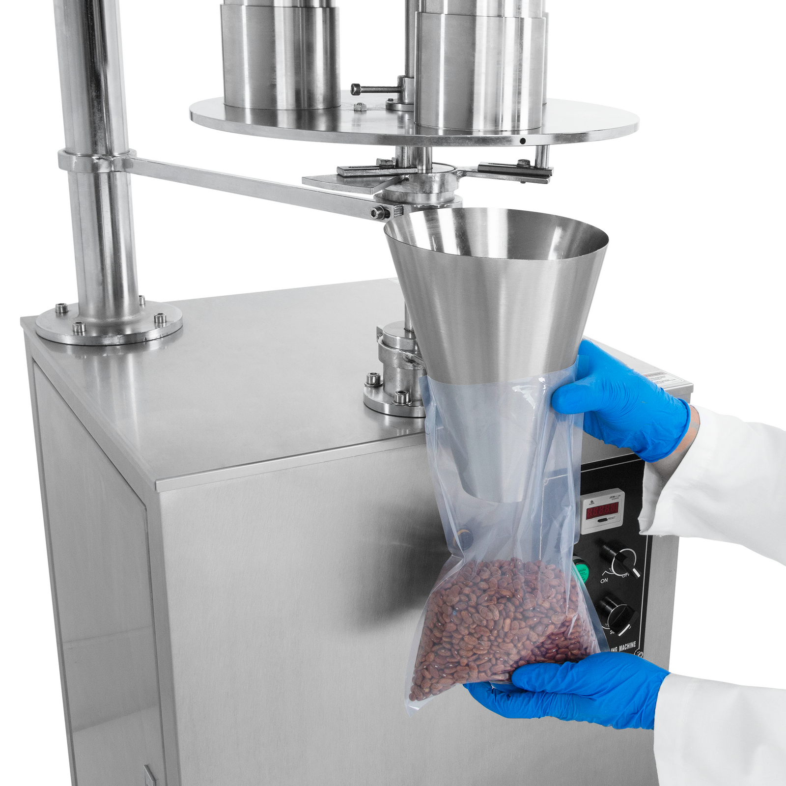 Close-up of the hands of a person holding a clear plastic bag under the dispensing cone of the semi automatic volumetric filler while it releases 500ml of free-flowing product with accuracy into the bag