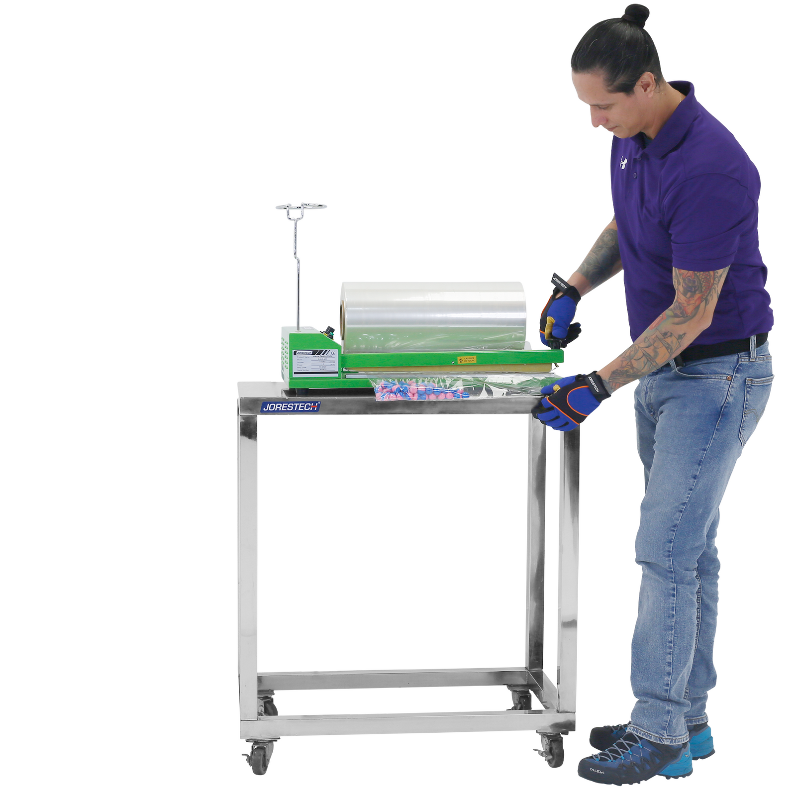 A person using a shrink bag sealer which is positioned on top of a JORES TECHNOLOGIES® Stainless steel prep work table