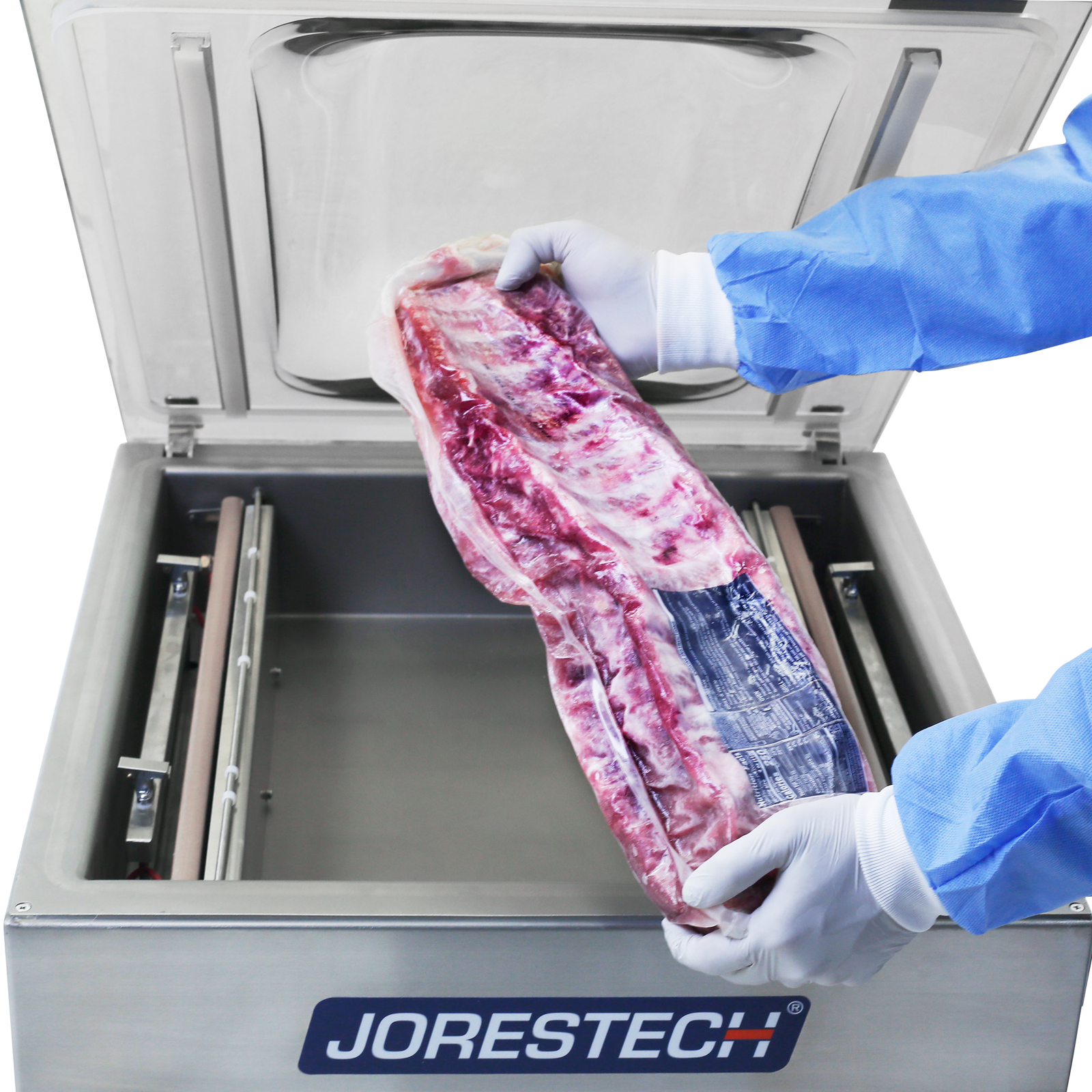 Person wearing disposable gloves and clothing. He is holding a large rack of ribs after been vacuumed by the stainless steel JORES TECHNOLOGIES® tabletop commercial single chamber vacuum sealer with dual seal bar in the background