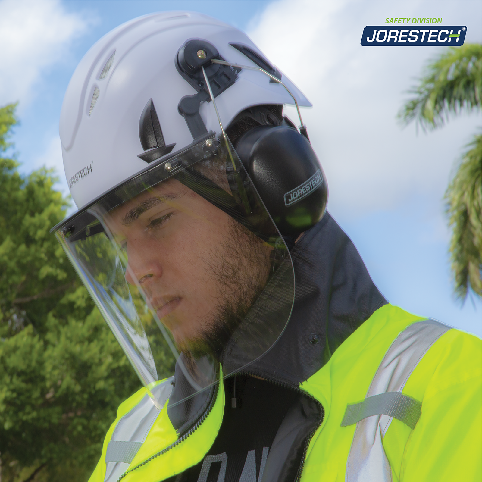 Worker wearing the ventilated safety work at height helmet system with face shield and ear muffs. He is also wearing a vi-si safety jacket while working outdoors. His face is protected by the JORESTECH face shield