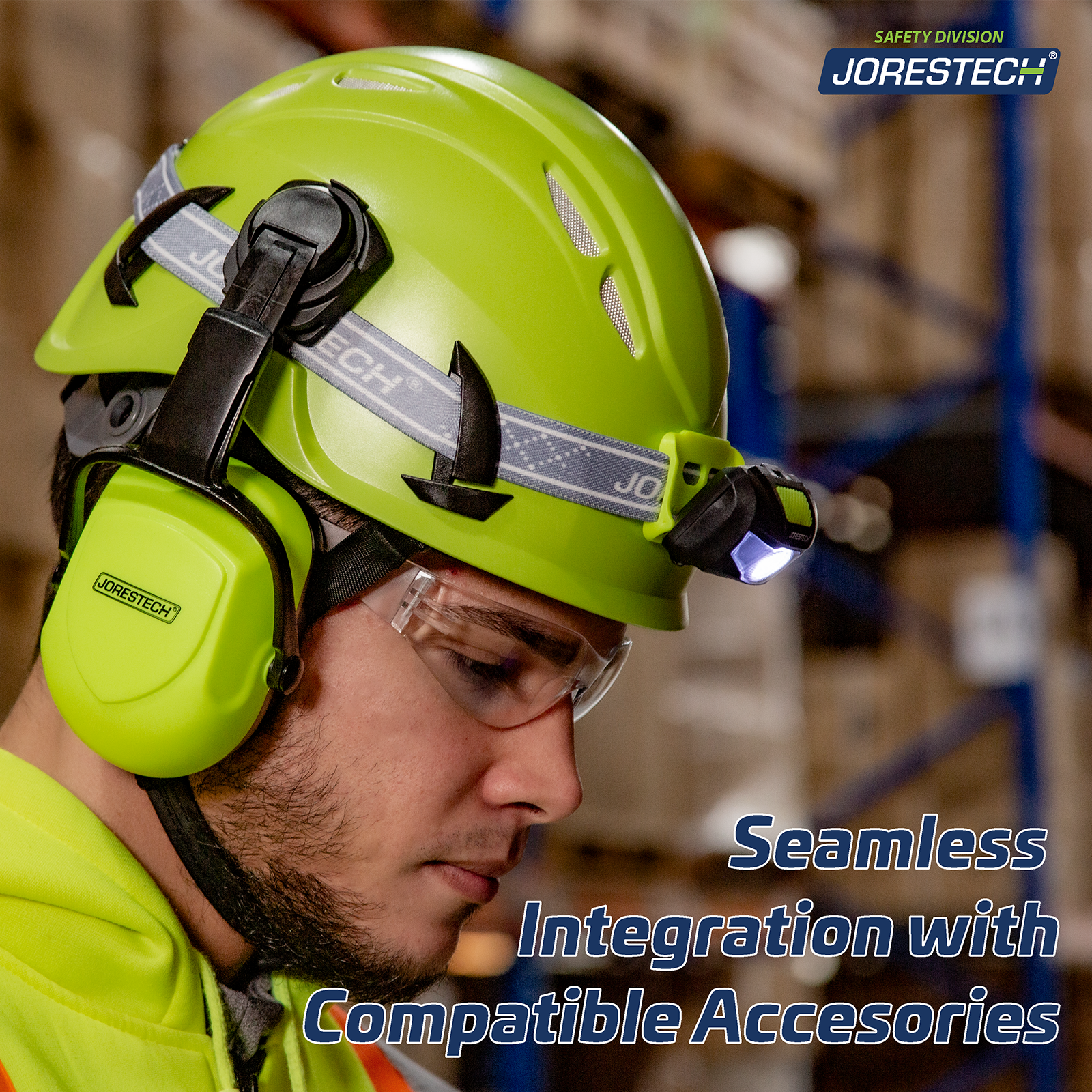 A man in a warehouse setting wearing the lime ventilated climbing hard hat with a blue text that reads: Seamless Integration with compatible accessories. The hard hat has a headlamp attachment as well as a pair of lime earmuffs