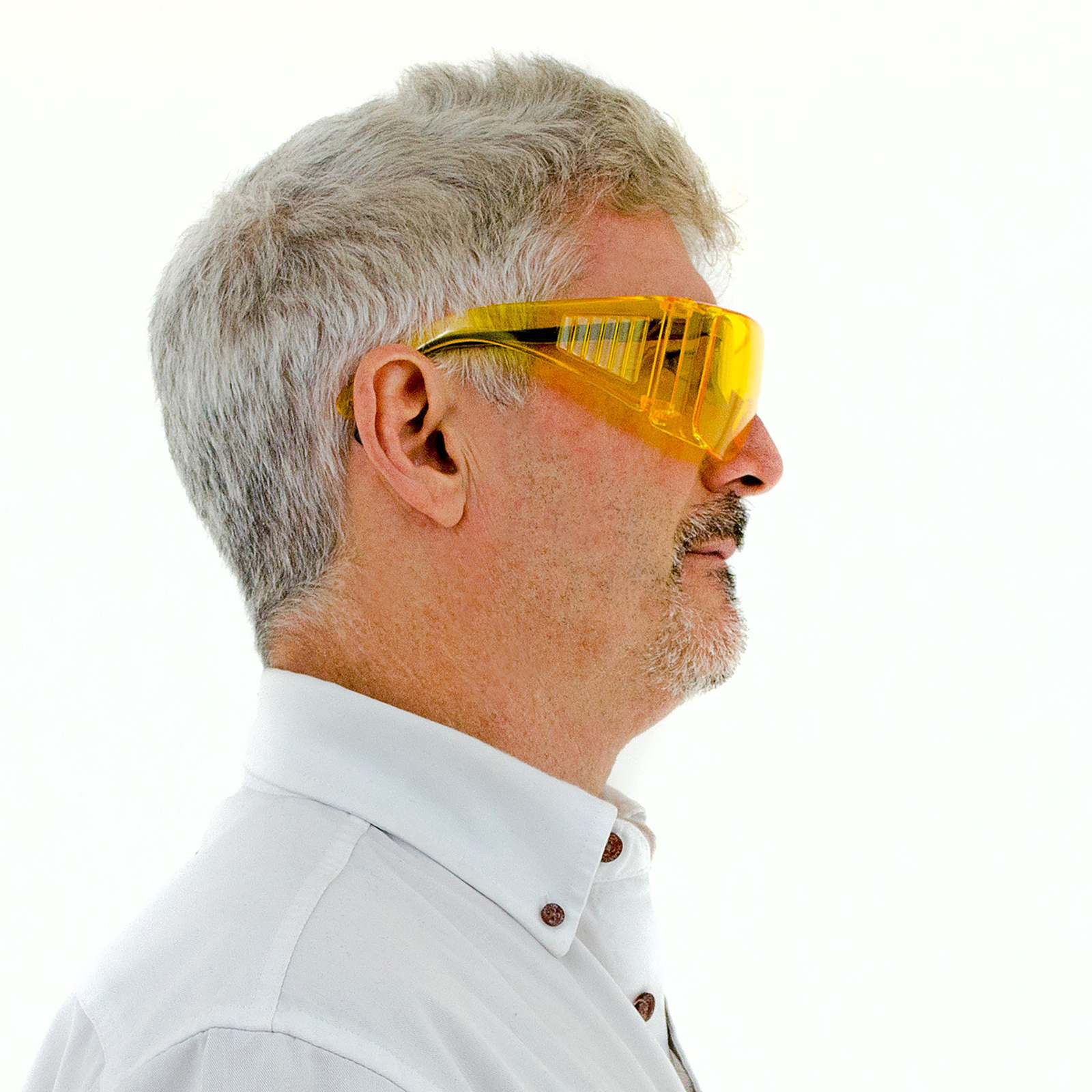 Side view of a man wearing the yellow Jorestech glasses over his own prescription glasses