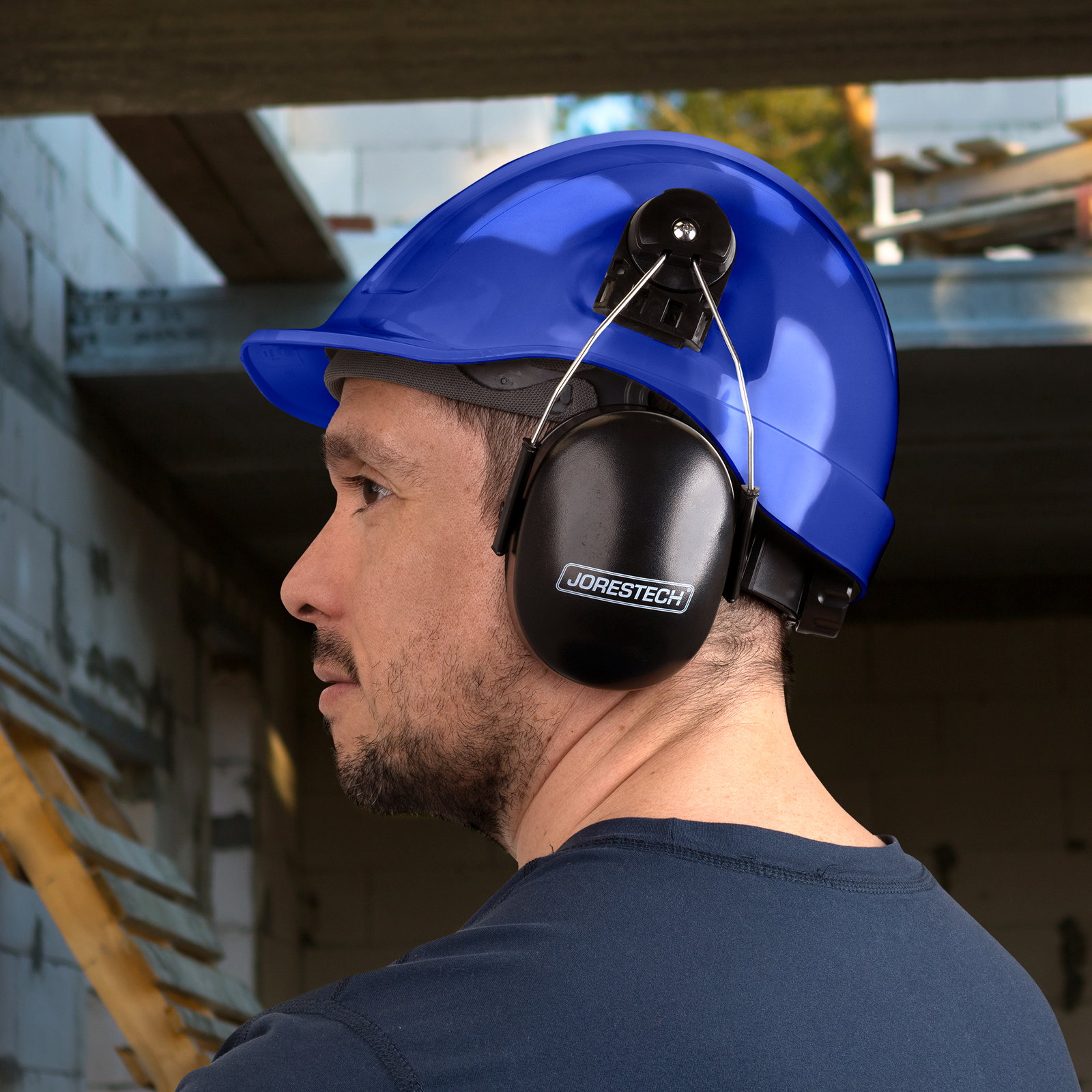 Worker wearing a slotted blue cap style hard hat with hearing protection
