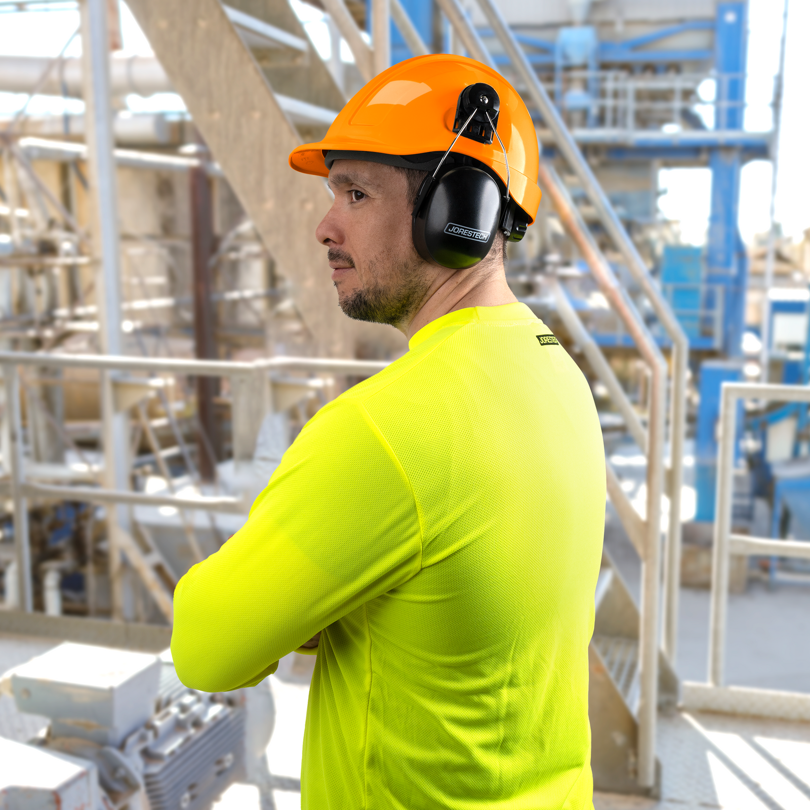 Worker wearing a slotted cap style hard hat with hearing protection