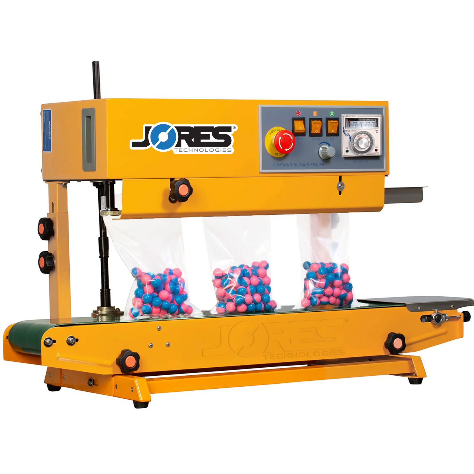 Yellow JORES TECHNOLOGIES® continuous band sealer sealing bags with blue and pink paint balls. The bag sealing machine is set in a vertical position and sealable bags are standing on the conveyor while being sealed 