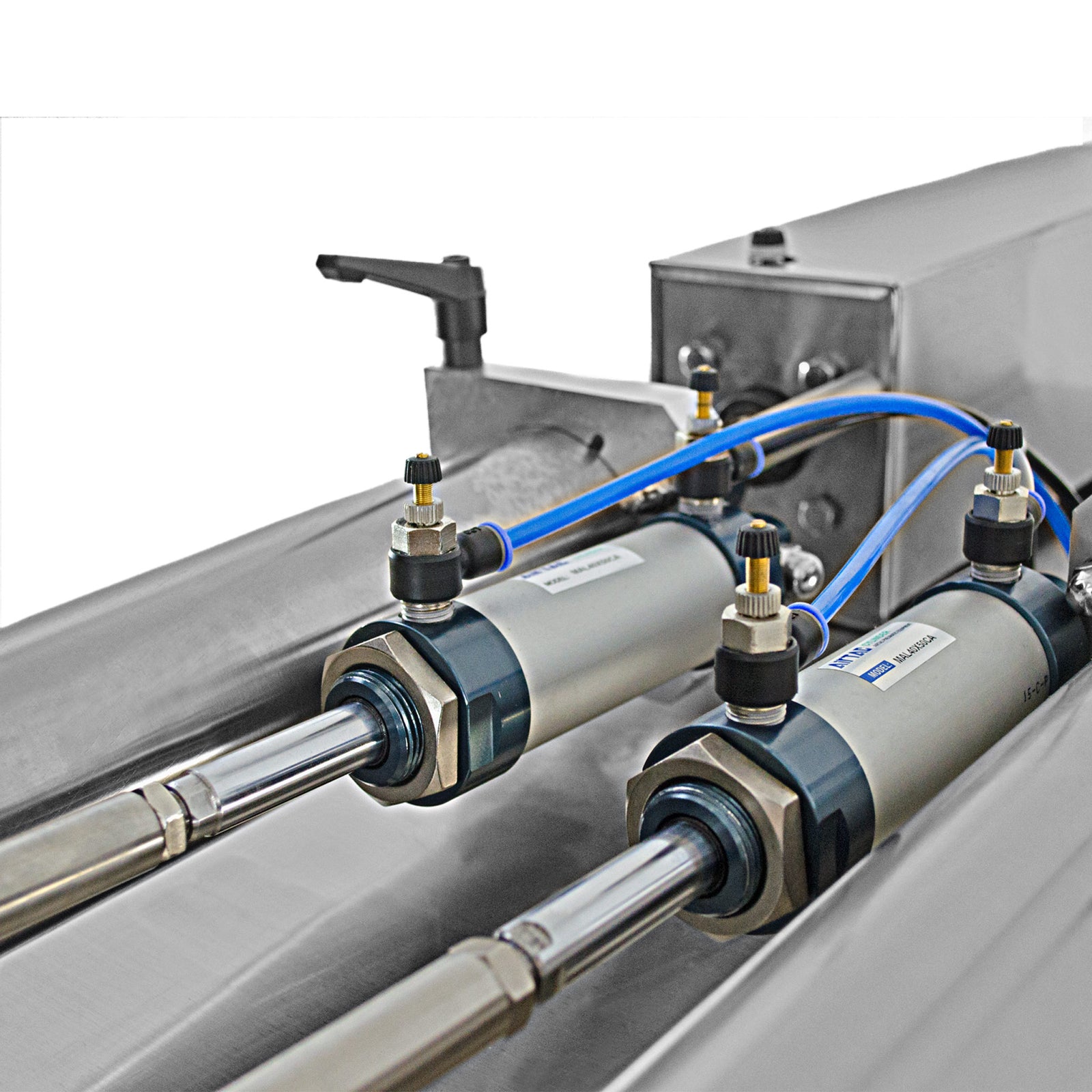 Close up of the two pistons that activate and move the dispensing valves which propel the liquid or paste out towards the nozzles of the dual head piston filler