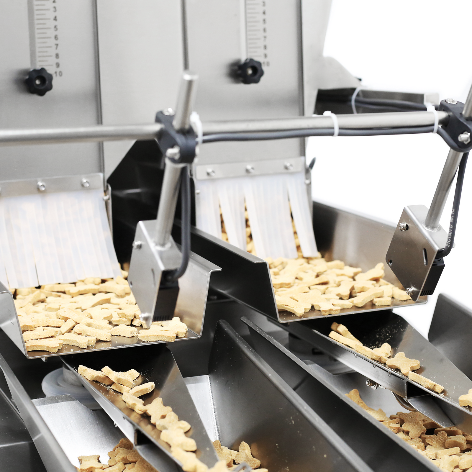 Close-up view of the JORES TECHNOLOGIES® stainless steel dual head linear weigher for 4000ml dispensing dog crackers