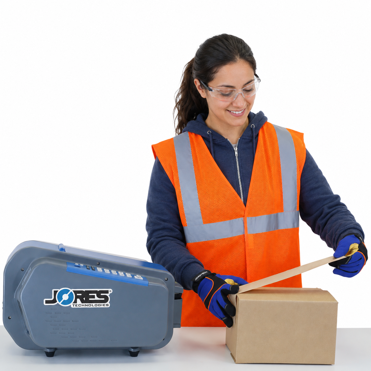 A worker wearing a hi vis safety vest filling the plastic water container of the JORES TECHNOLOGIES® electric gummed tape dispenser. The action takes place in a warehouse full on bins with taped card boxes 