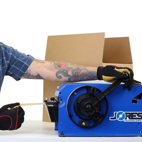man pulling the black handle on blue JORES TECHNOLOGIES® gummed kraft paper tape dispenser to roll out brown paper kraft tape and place it on an open card box