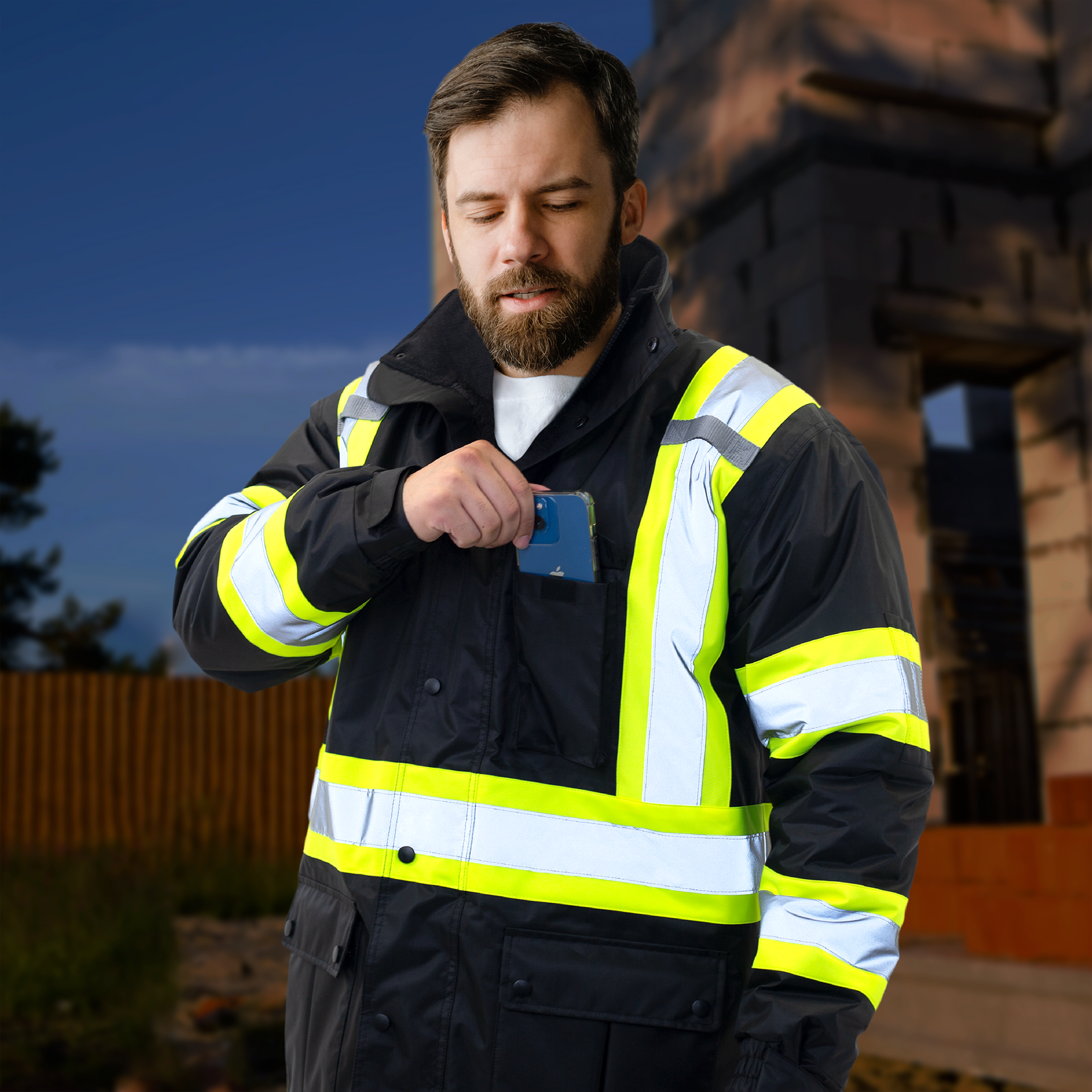 Worker wearing the insulated black high visibility jacket with reflective and yellow stripes