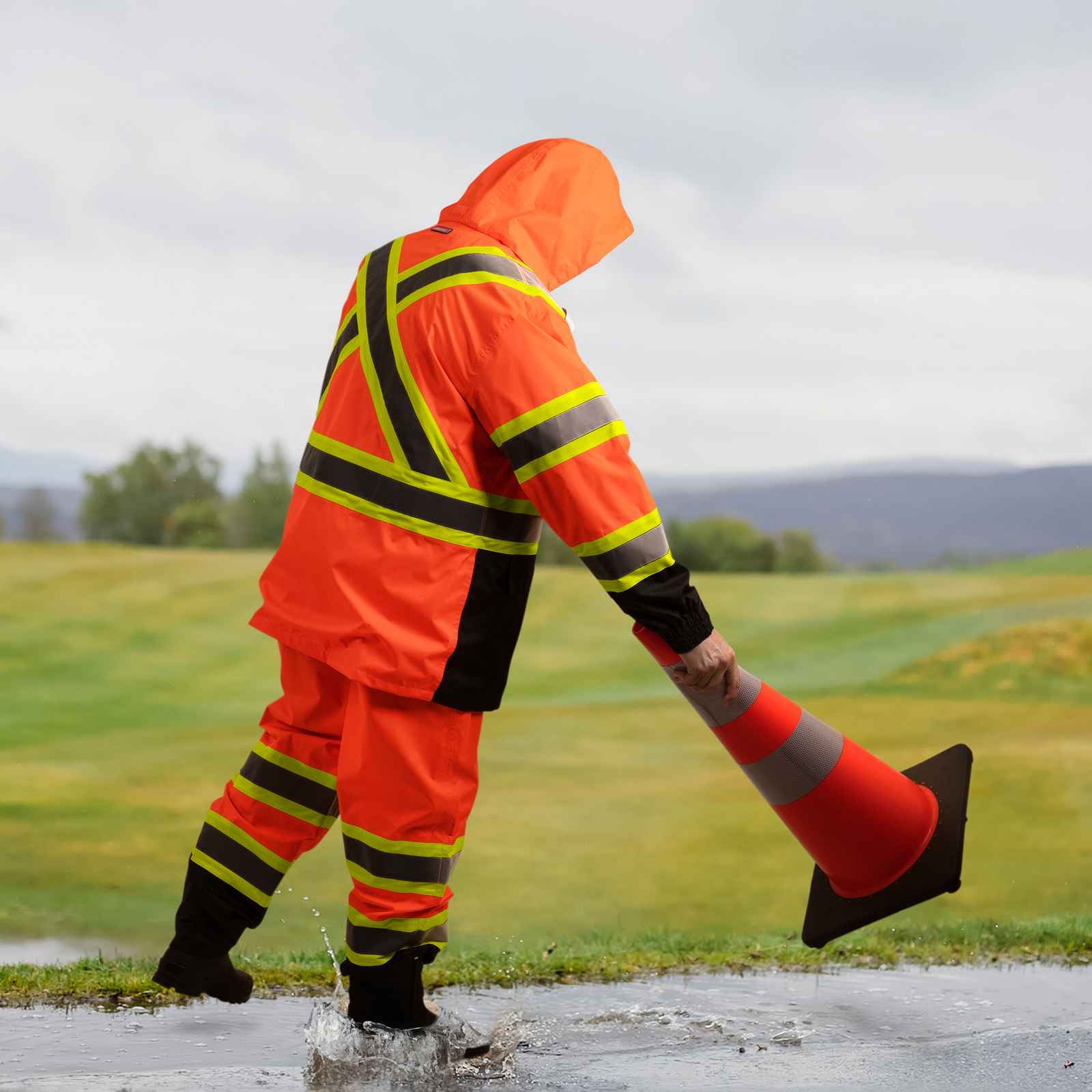 Worker wearing the hi vis orange safety rain set for weather protection
