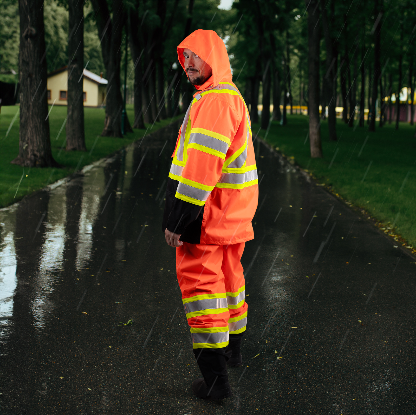 Worker wearing the hi vis orange safety rain set for weather protection