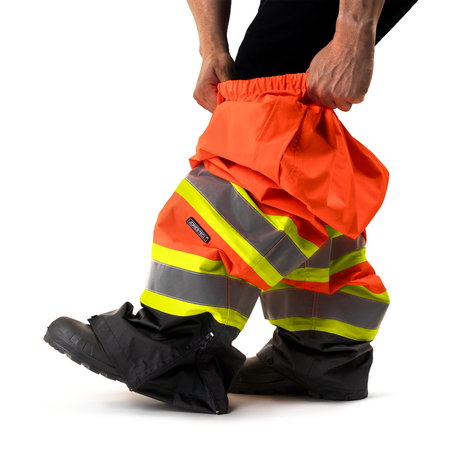 Worker wearing the High visibility safety rain pants as a rain proof protective layer on top of his clothes