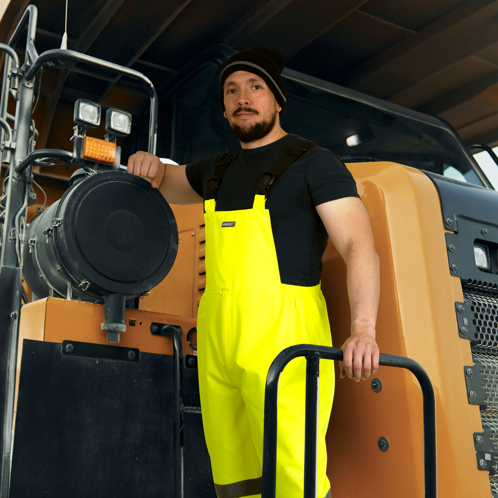 Worker wearing the hi vis overall pants with reflective stripes