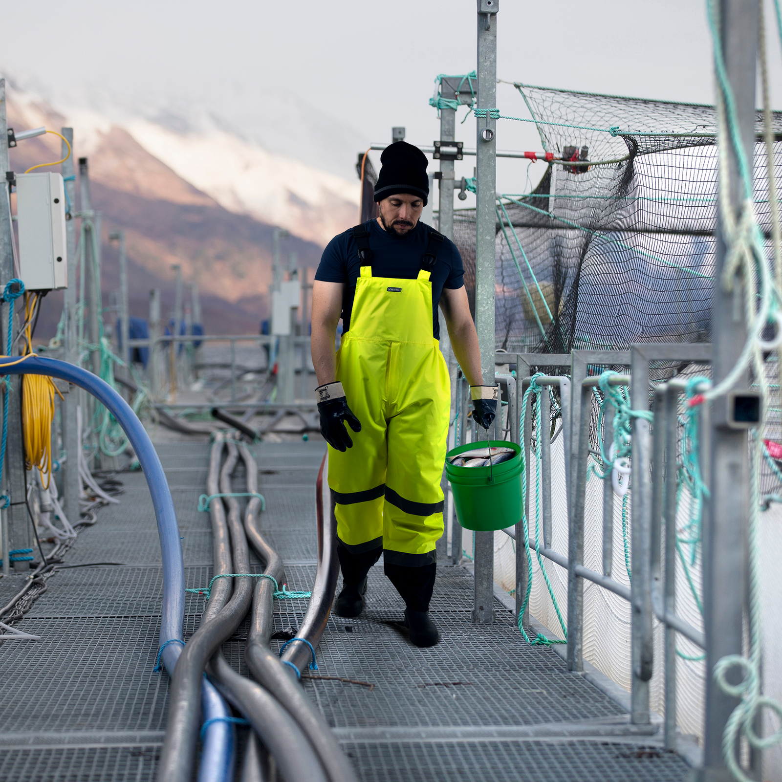 Fisherman wearing the hi vis waterproof safety overall pant with reflective stripes for weather protection