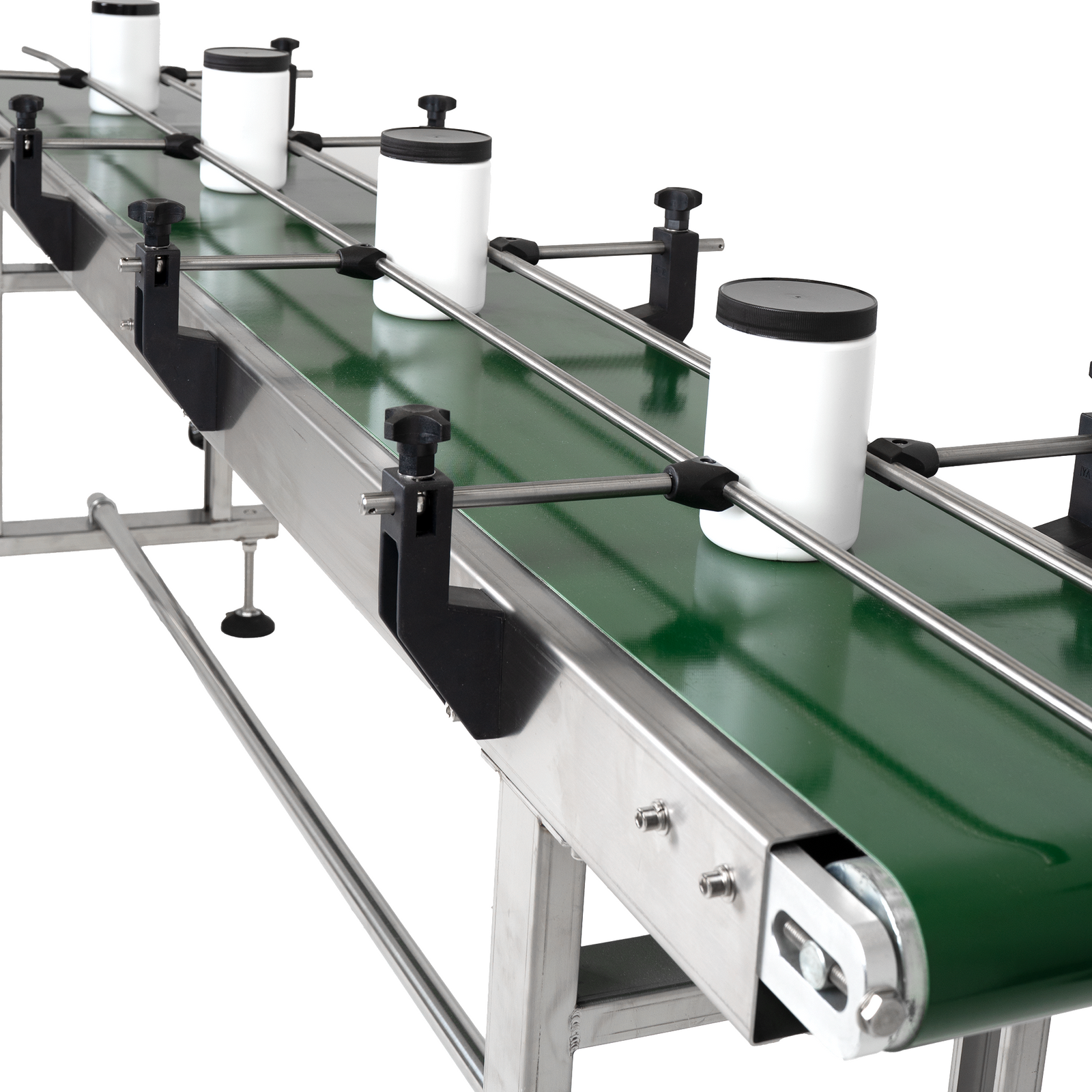 long motorized stainless steel belt conveyor with rubber belt with several white bottles on the moving conveyor