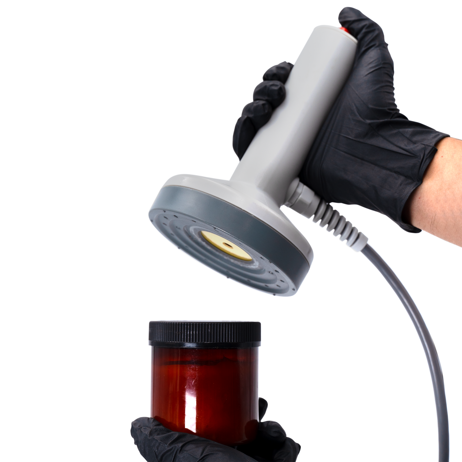 Worker sealing a plastic container with an induction liner using a JORESTECH manual induction sealer 
