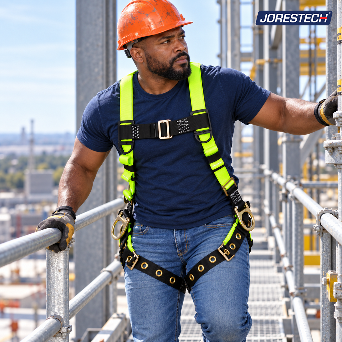 Jorestech S-HARN-04 high-visibility lime-yellow industrial safety harness with side positioning D-rings and black grommeted tongue buckle leg straps, shown on a male construction worker walking along an elevated outdoor industrial scaffolding catwalk wearing an orange hard hat.