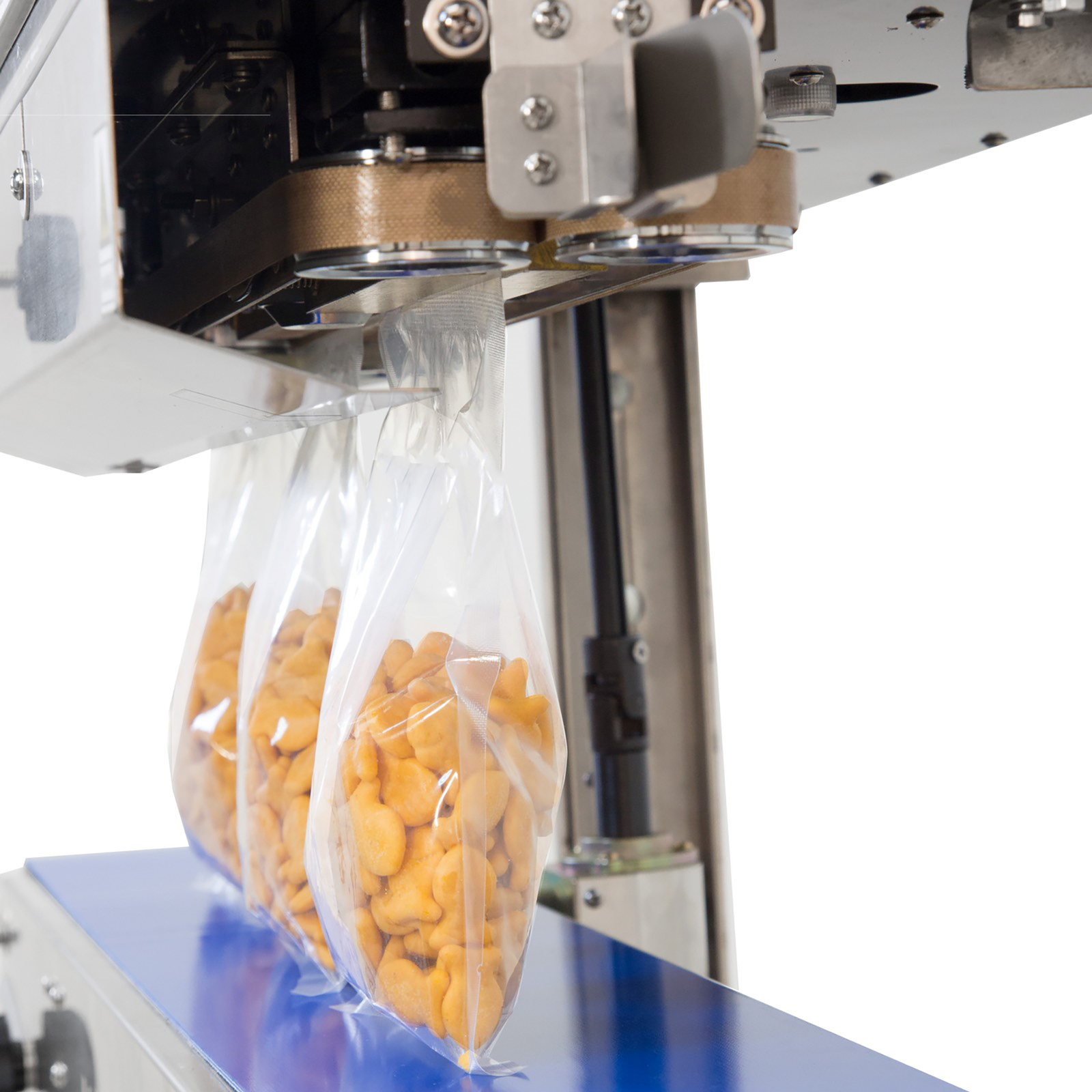 3 plastic bags filled with orange crackers being sealed by a Vertical and Horizontal stainless steel JORES TECHNOLOGIES® continuous band sealer. 