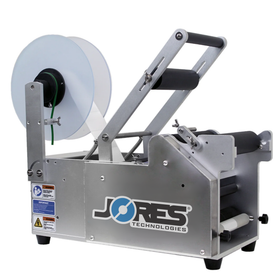 Semi automatic label applicator for round containers. Labeler has a JORES TECHNOLOGIES® logo, safety stickers with instructions and large clear blue roll dispenser with self adhesive labels