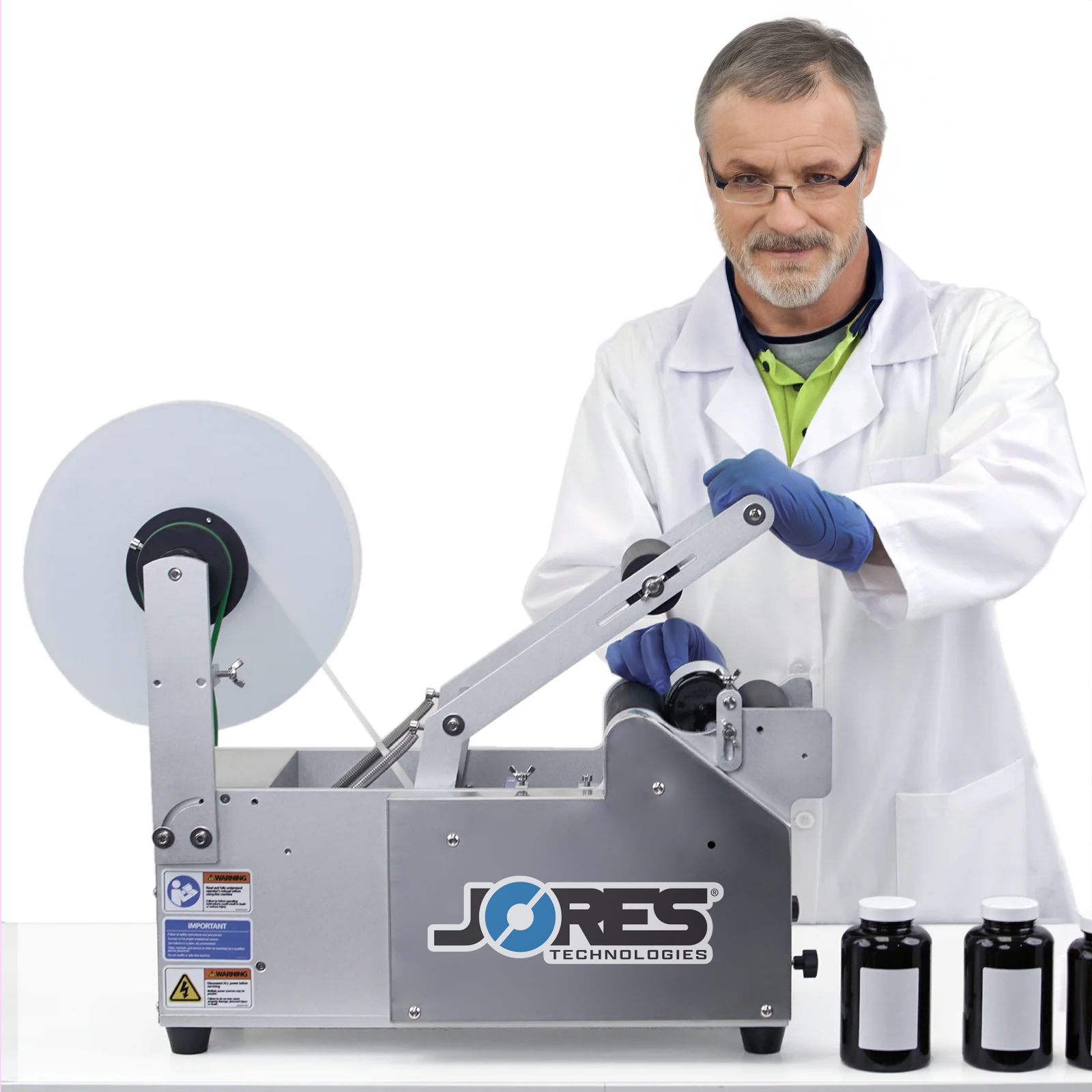 Man wearing personal protection equipment while operating the JORES TECHNOLOGIES® semi automatic labeling machine by pushing the activation handle to apply labels to round containers