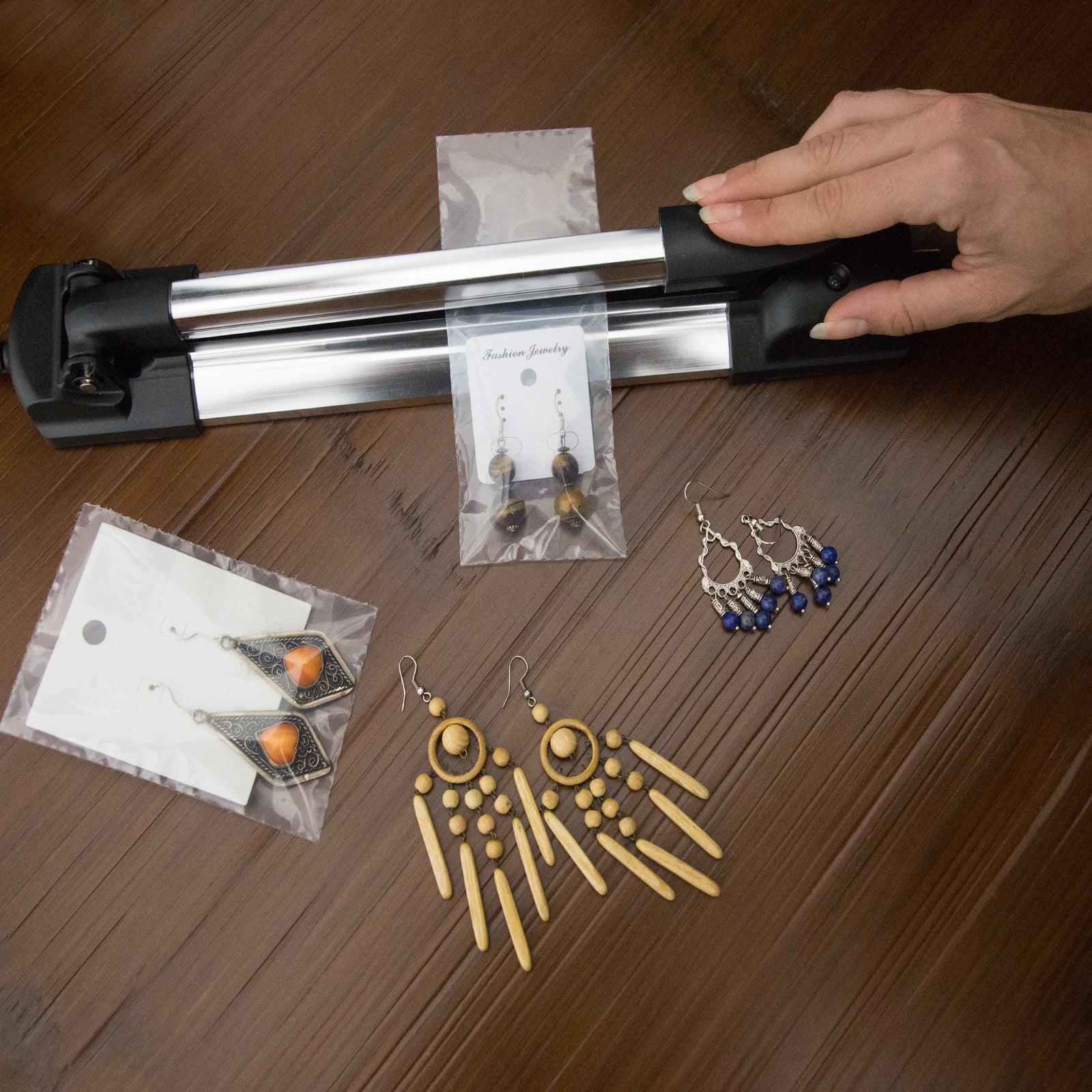 Top view of a manual Impulse Heat Sealer being used to seal a sealable bag with hand crafted jewelry inside