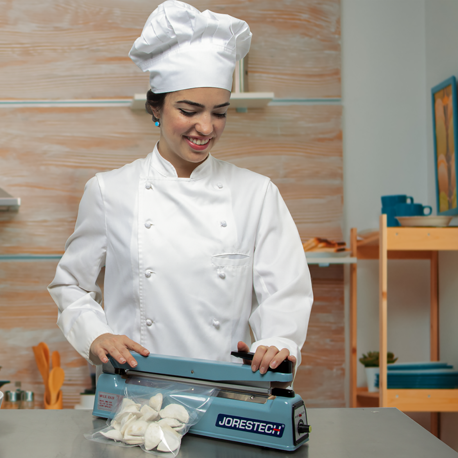 Young chef in an industrial kitchen heat sealing bags of dumplings with the JORES TECHNOLOGIES® manual impulse sealer