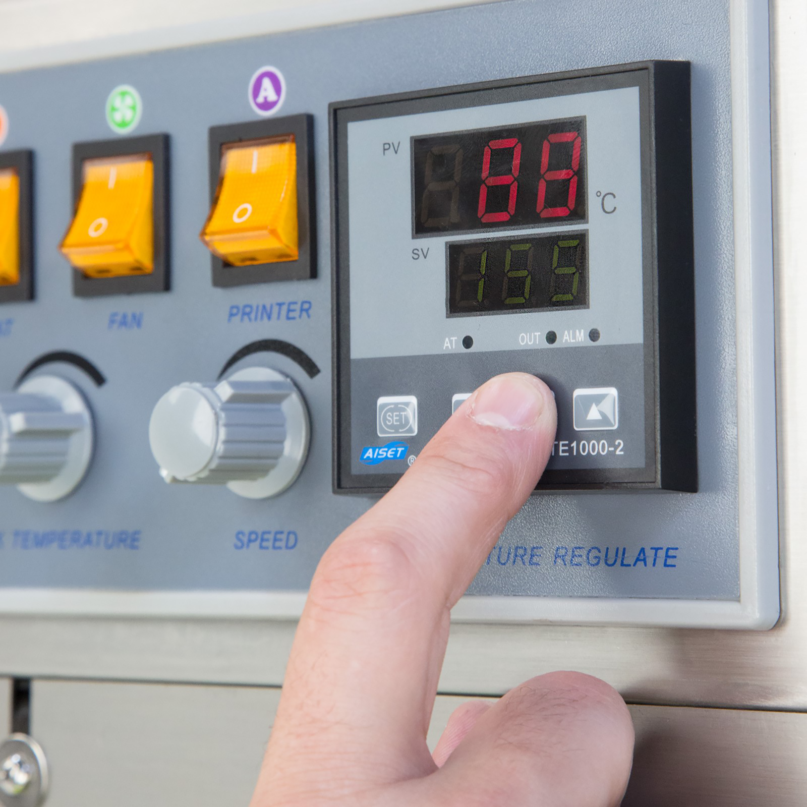 operator adjusting the heating temperature on the digital control panel of a JORES TECHNOLOGIES® continuous band sealer